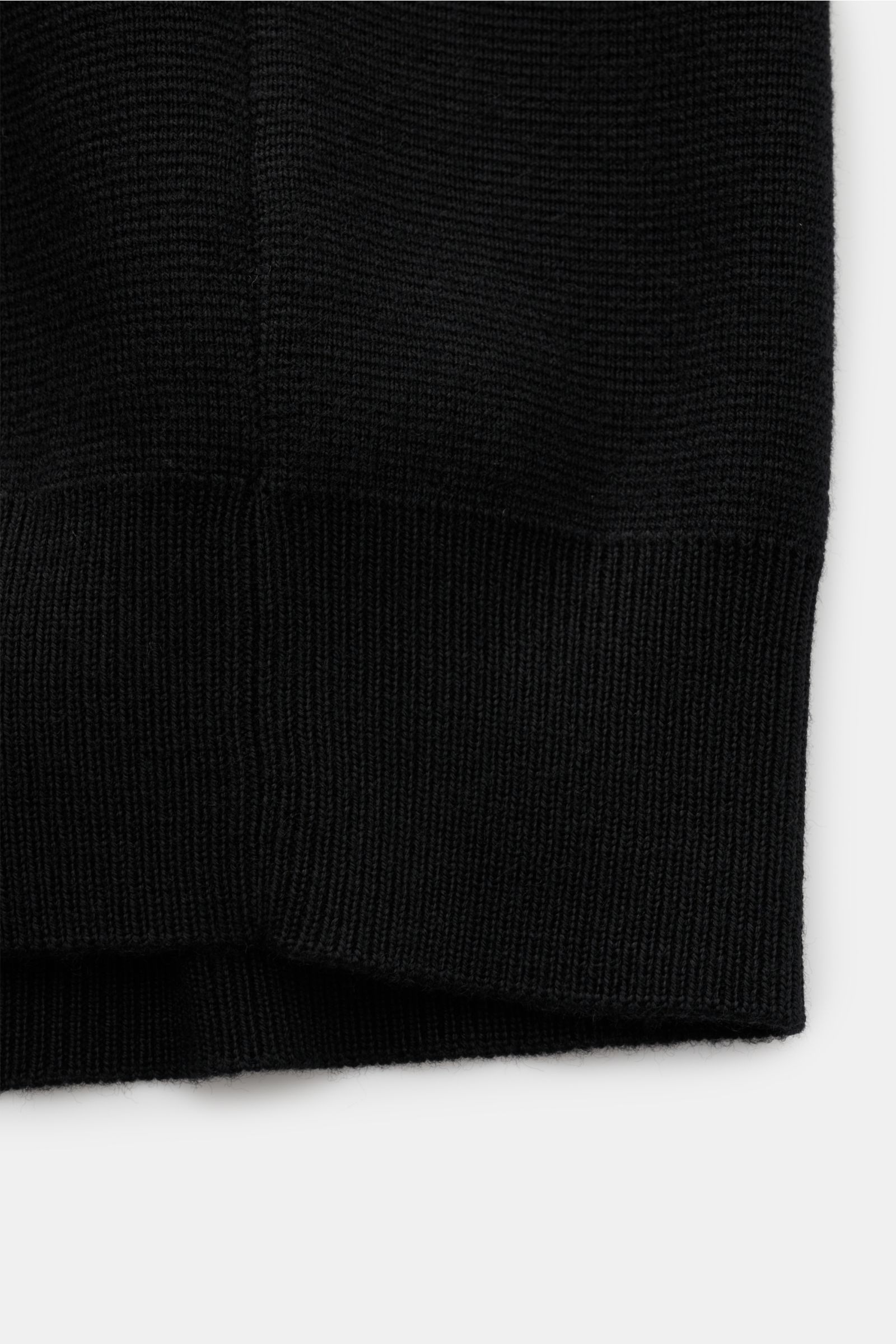 Close-up of the ribbed cuff and knit texture of the Filippo de Laurentiis Merino Cardigan schwarz, photographed from the side. Für zeitlose Looks im Winter: Der Cardigan von FILIPPO DE LAURENTIIS garantiert Komfort sowie stilvolle Eleganz und hält mit sei