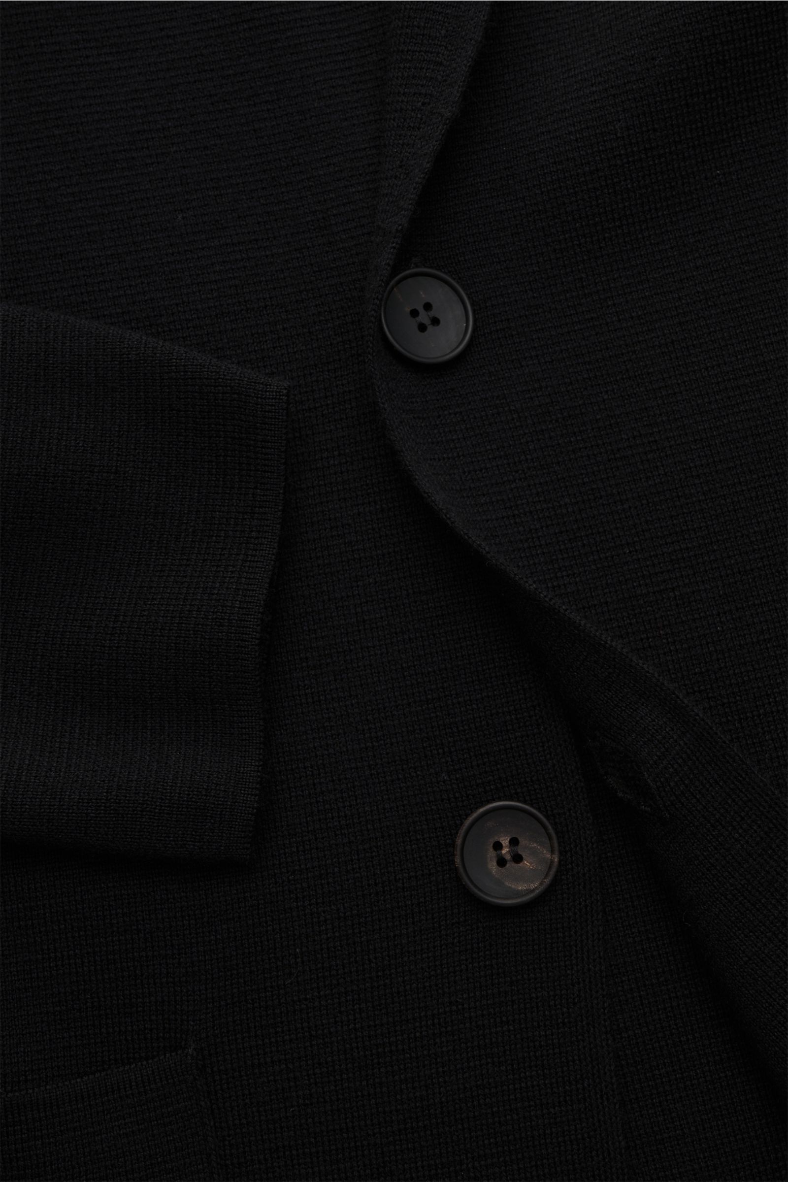 Filippo de Laurentiis Merino Cardigan schwarz in Slim Fit, aus reiner Merinowolle, schwer fein gestrickt, strukturierter Griff, Reverskragen, Zwei-Knopf-Leiste, aufgesetzte Fronttaschen, Detailfoto von vorne oben.