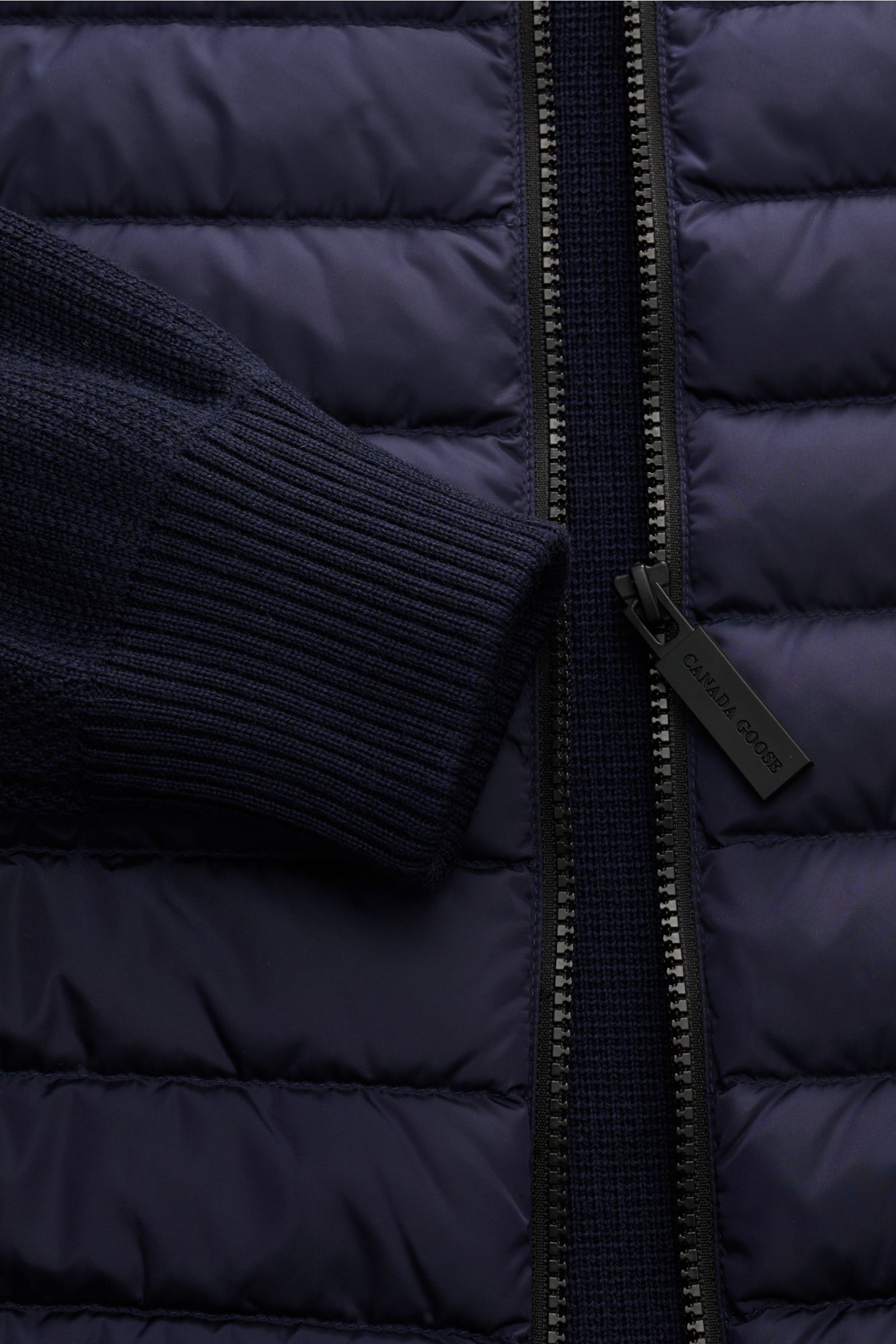 Close-up der Canada Goose Strickjacke 'Hybridge Knit' navy mit Daunen-Front, Wollstrick, Reißverschluss und flexiblem Rippbündchen.