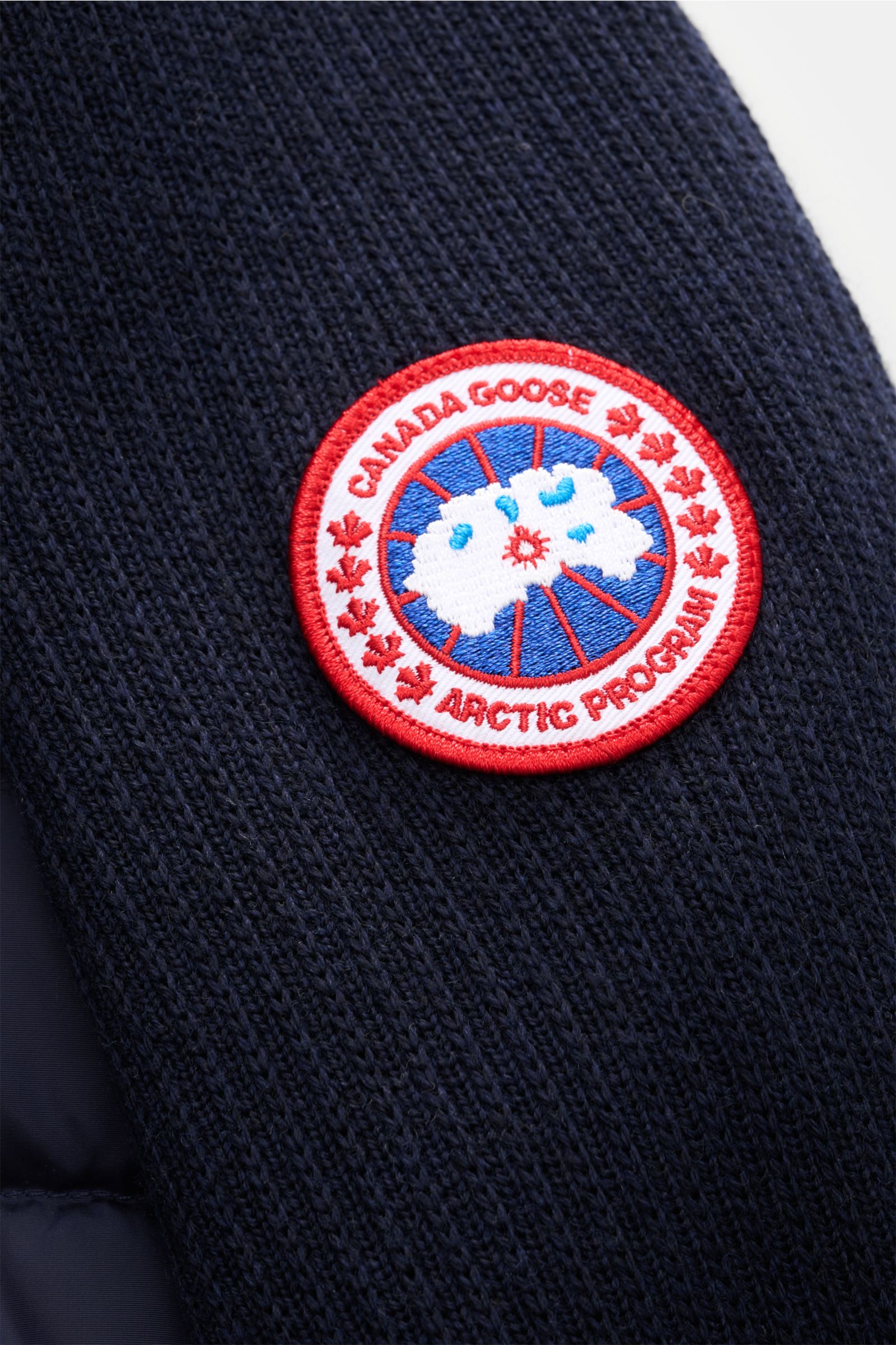 Canada Goose Strickjacke 'Hybridge Knit' navy im Detail von schräg oben, mit Wolle, strukturierter Oberfläche, Daunen-Front, Weblabel am Oberarm.
