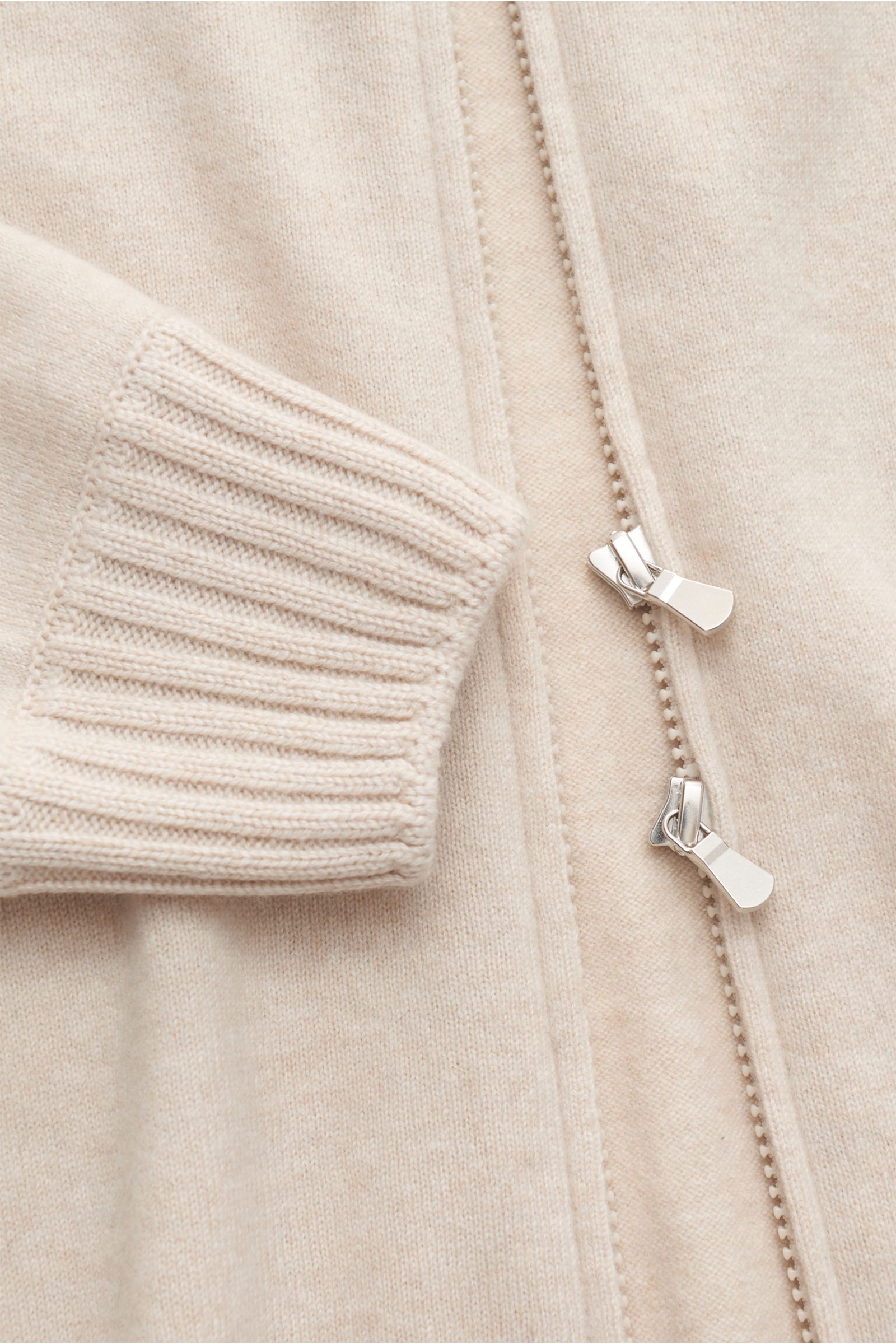 Gran Sasso Cashmere Strickjacke sand shown in close-up from above, highlighting soft cashmere fabric, ribbed cuff, and two-way zipper. Sportives Basic von GRAN SASSO: Diese edle Strickjacke wurde aus anschmiegsamem Cashmere gefertigt und ist die perfek