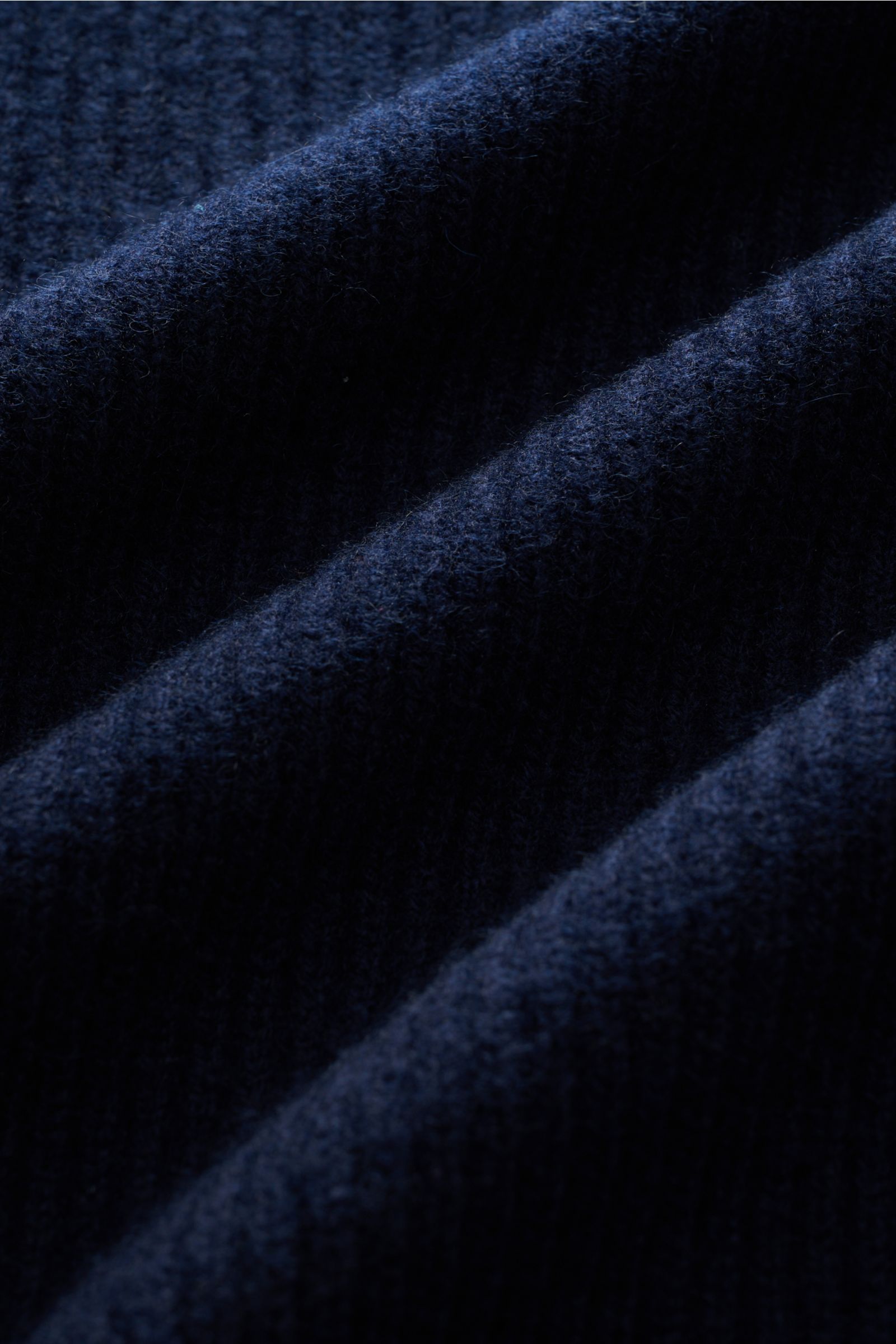 Close-up image of the Gran Sasso Rundhalspullover navy fabric from a top-down perspective, showing reine Baumwolle, weicher Griff, feines Strickbild, Slim Fit, Rundhalsausschnitt, and komfortable Rippbündchen.