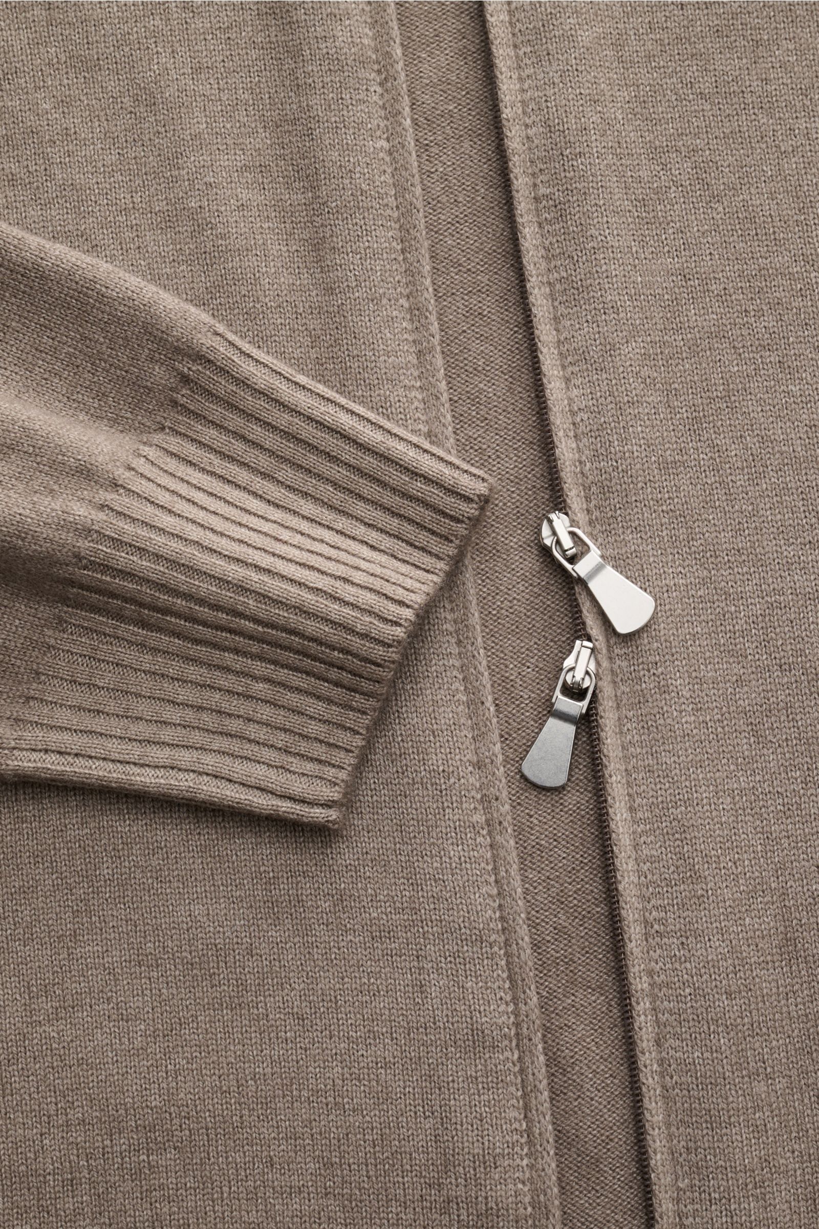Close-up front view of the BRAUN Hamburg Strickjacke taupe showing soft knit, ribbed cuffs, and dual zipper pulls in taupe color. Zeitlose Eleganz trifft Komfort: Die besonders weiche sowie wärmende Strickjacke von BRAUN HAMBURG wird an kalten Tagen zu