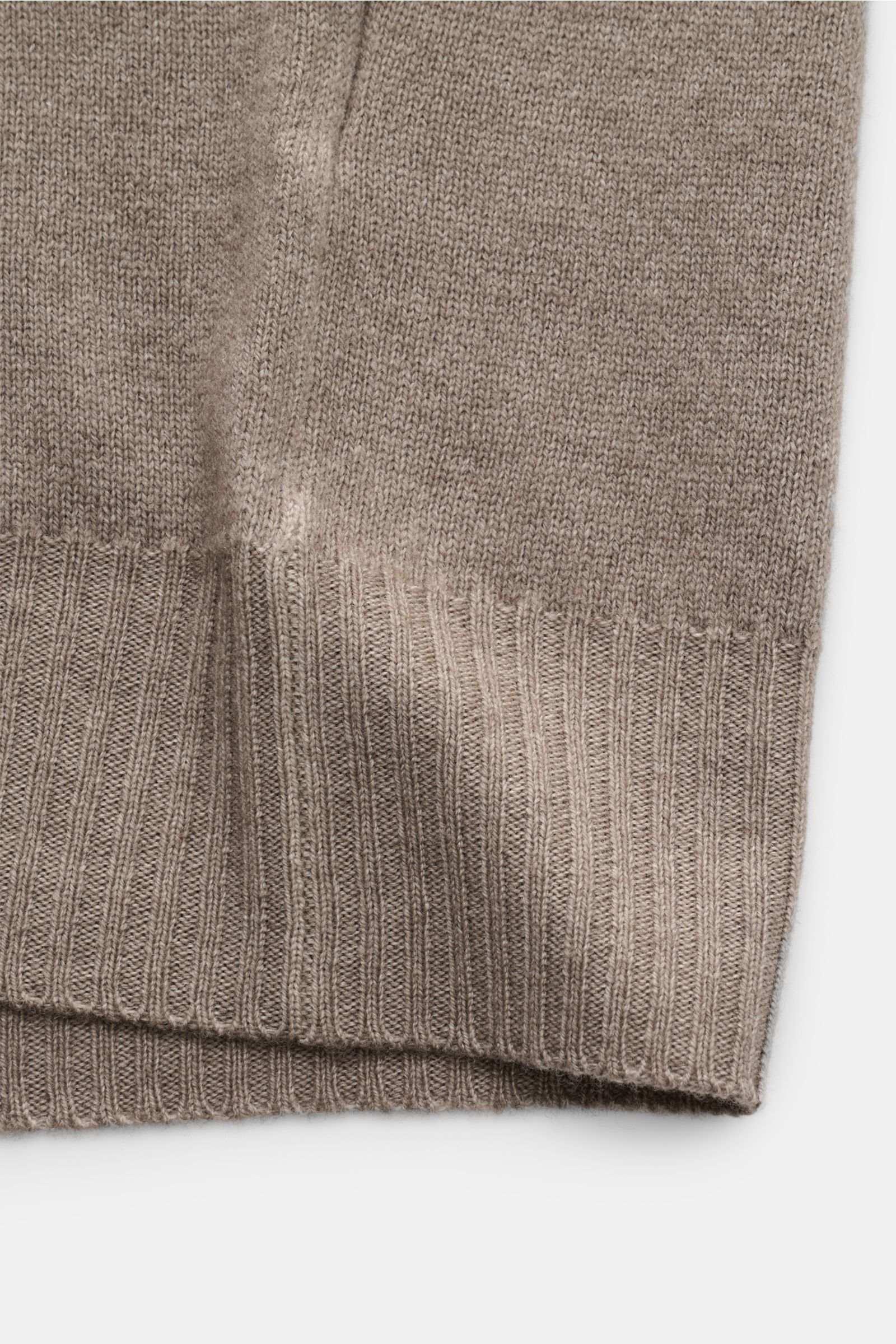 Close-up front view of the ribbed hem and fine knit texture of the BRAUN Hamburg Strickjacke taupe in soft, warm wool blend.

Description: 
Zeitlose Eleganz trifft Komfort: Die besonders weiche sowie wärmende Strickjacke von BRAUN HAMBURG wird an kalte