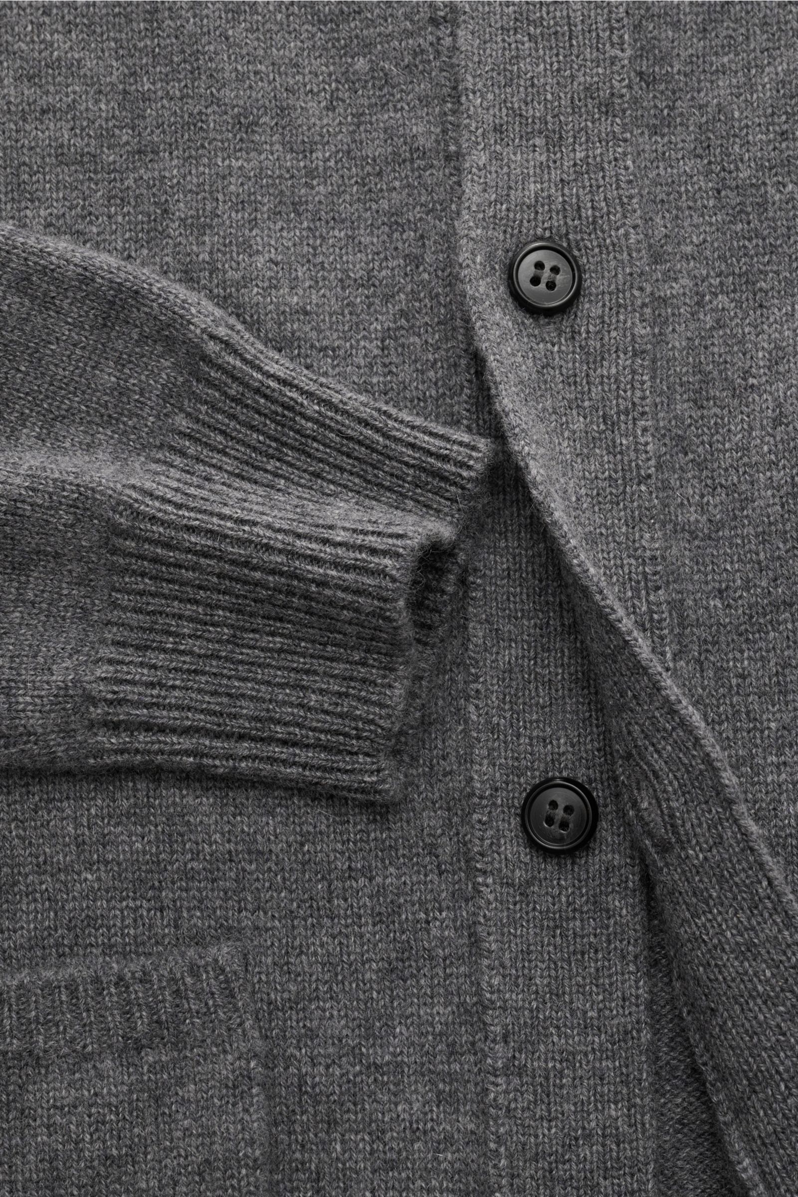 Close-up top-down view of Lisa Yang Cashmere cardigan 'Maximilian' grey melange showing soft pure cashmere fabric, ribbed cuff, six-button placket, and patch hip pocket.

A modern essential for your wardrobe: With the LISA YANG label, you can always be