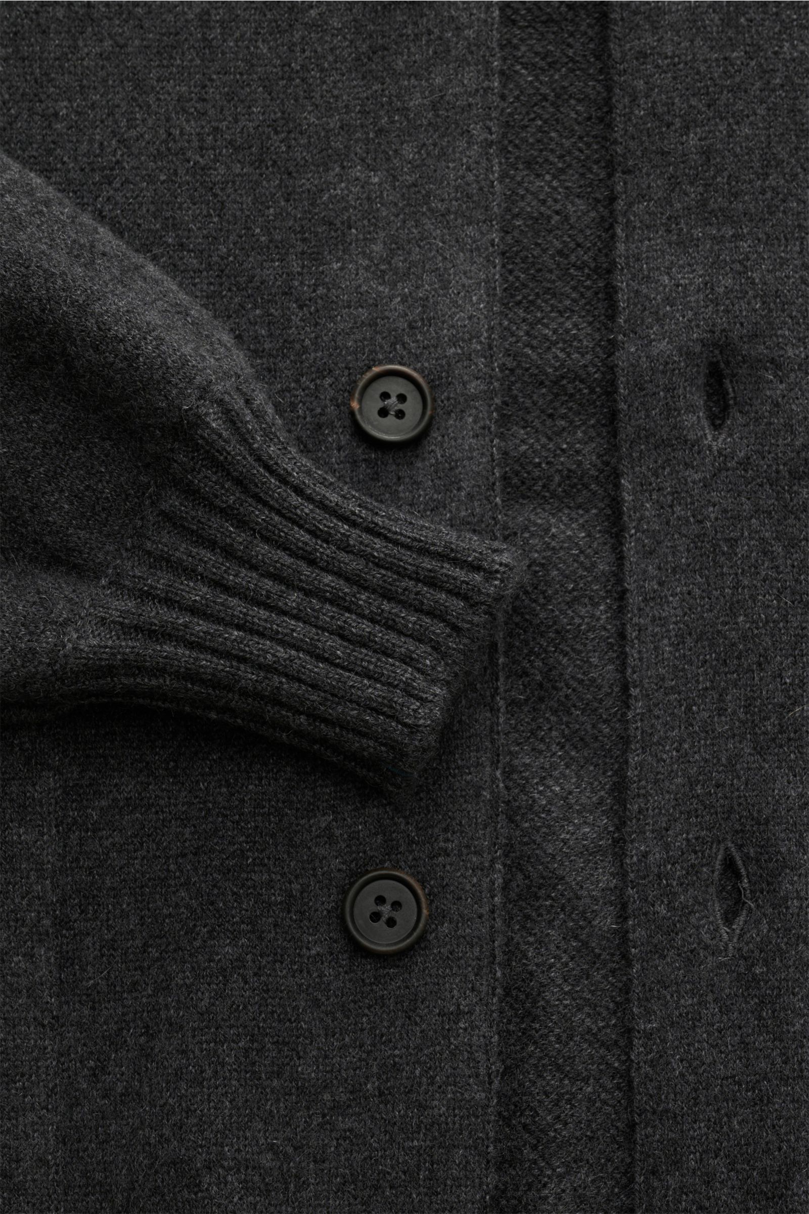 Close-up from above of the Fioroni Cashmere Cardigan dunkelgrau meliert showing its soft, fine knit with leather-reinforced button placket and ribbed cuff.

Description: Luxuriöser Cashmere für kalte Tage: Mit seinem besonders angenehmen, wärmenden Materi