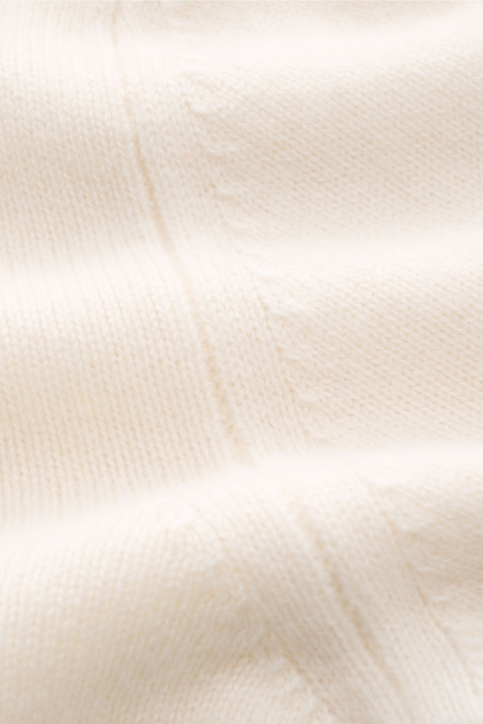 Nahaufnahme der Lunaria Cashmere Cashmere Strickjacke offwhite mit feinem Strickbild und markanten Rippbündchen aus 100% Cashmere.