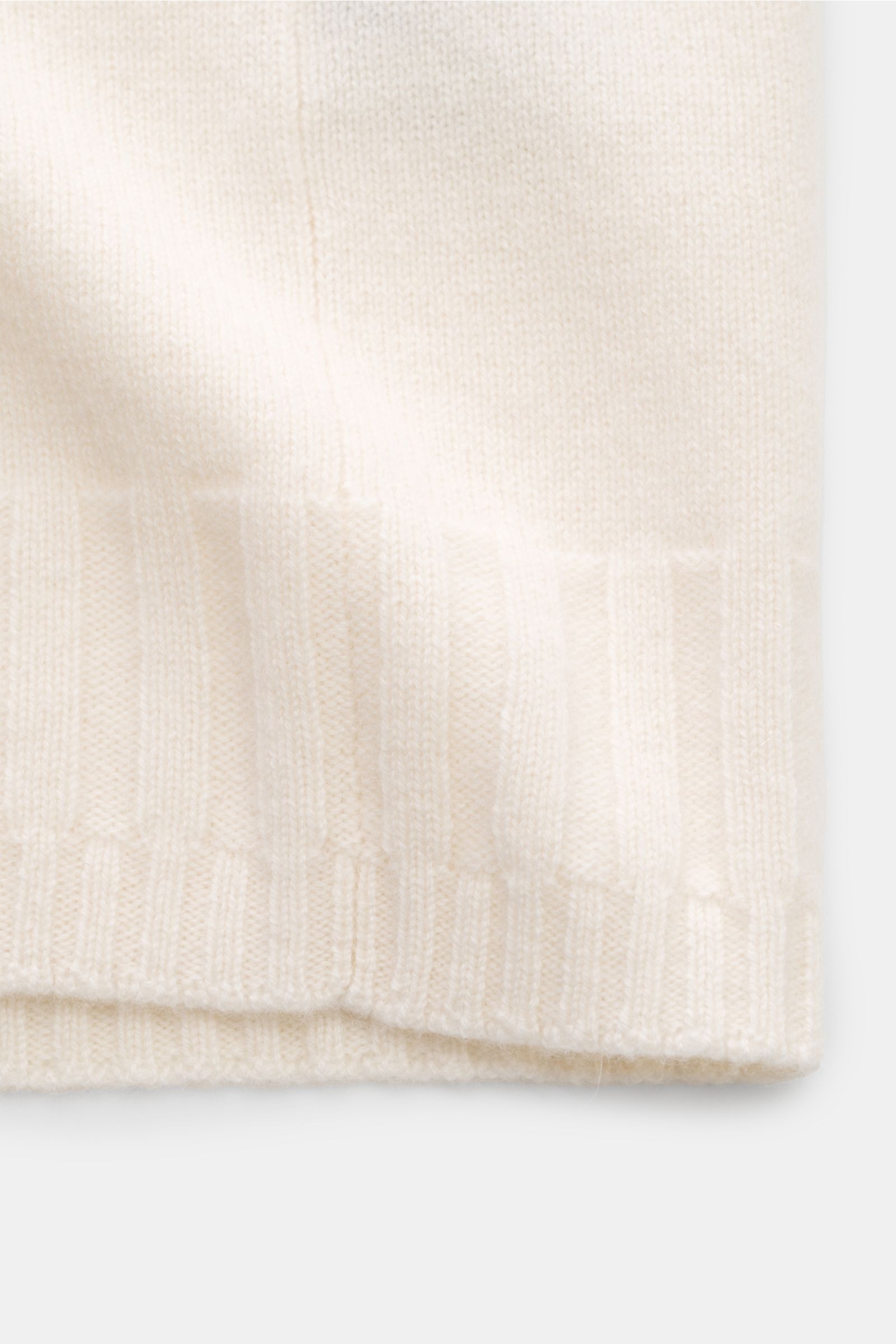 Nahaufnahme der Lunaria Cashmere Cashmere Strickjacke offwhite von unten, zeigt weichen Griff, feines Strickbild und flexible Rippbündchen.