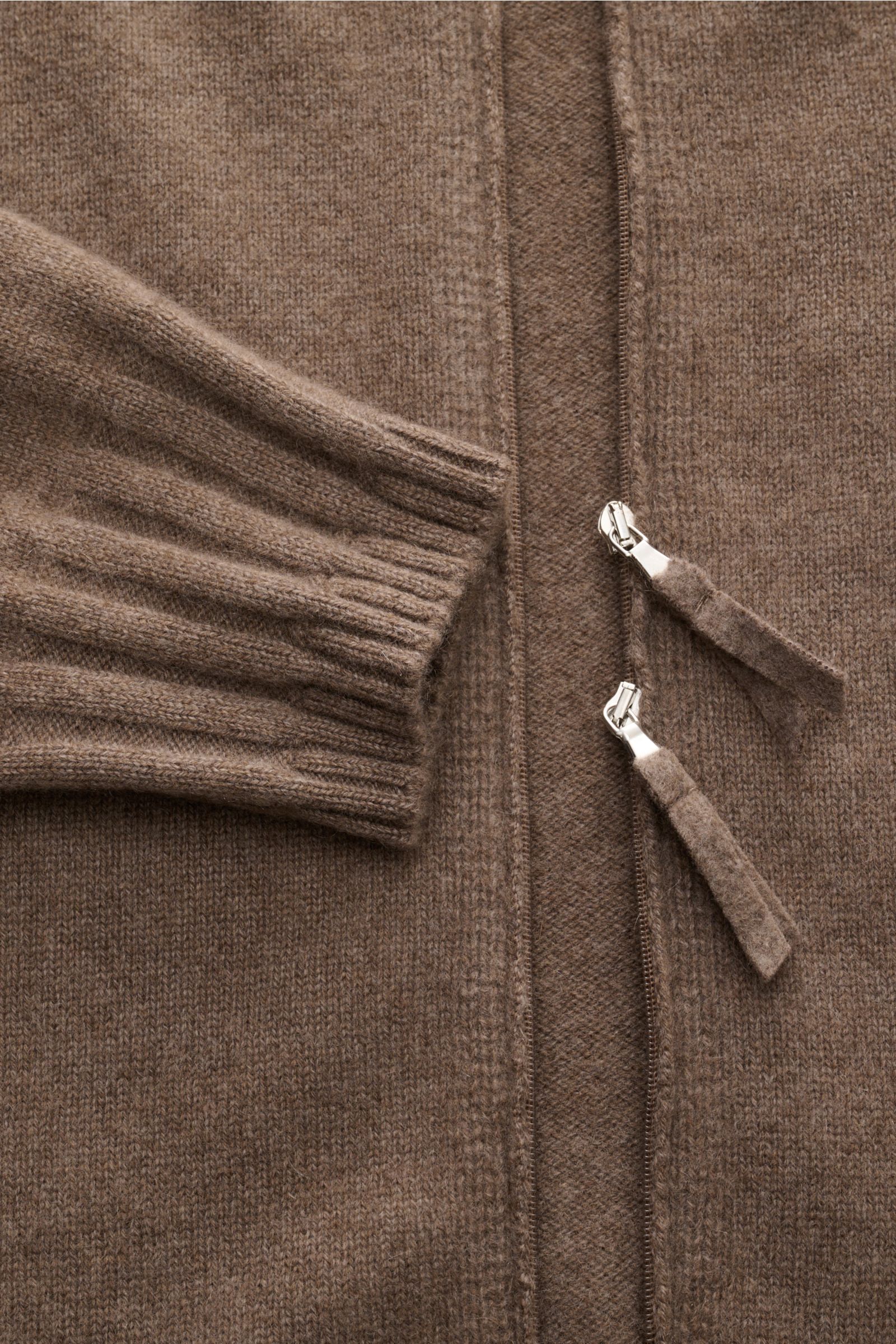 Nahaufnahme der graubraunen Lunaria Cashmere Cashmere Strickjacke aus 100% weichem Cashmere mit feinem Strickbild, Rippbündchen und zwei-Wege-Reißverschluss, fotografiert von oben.