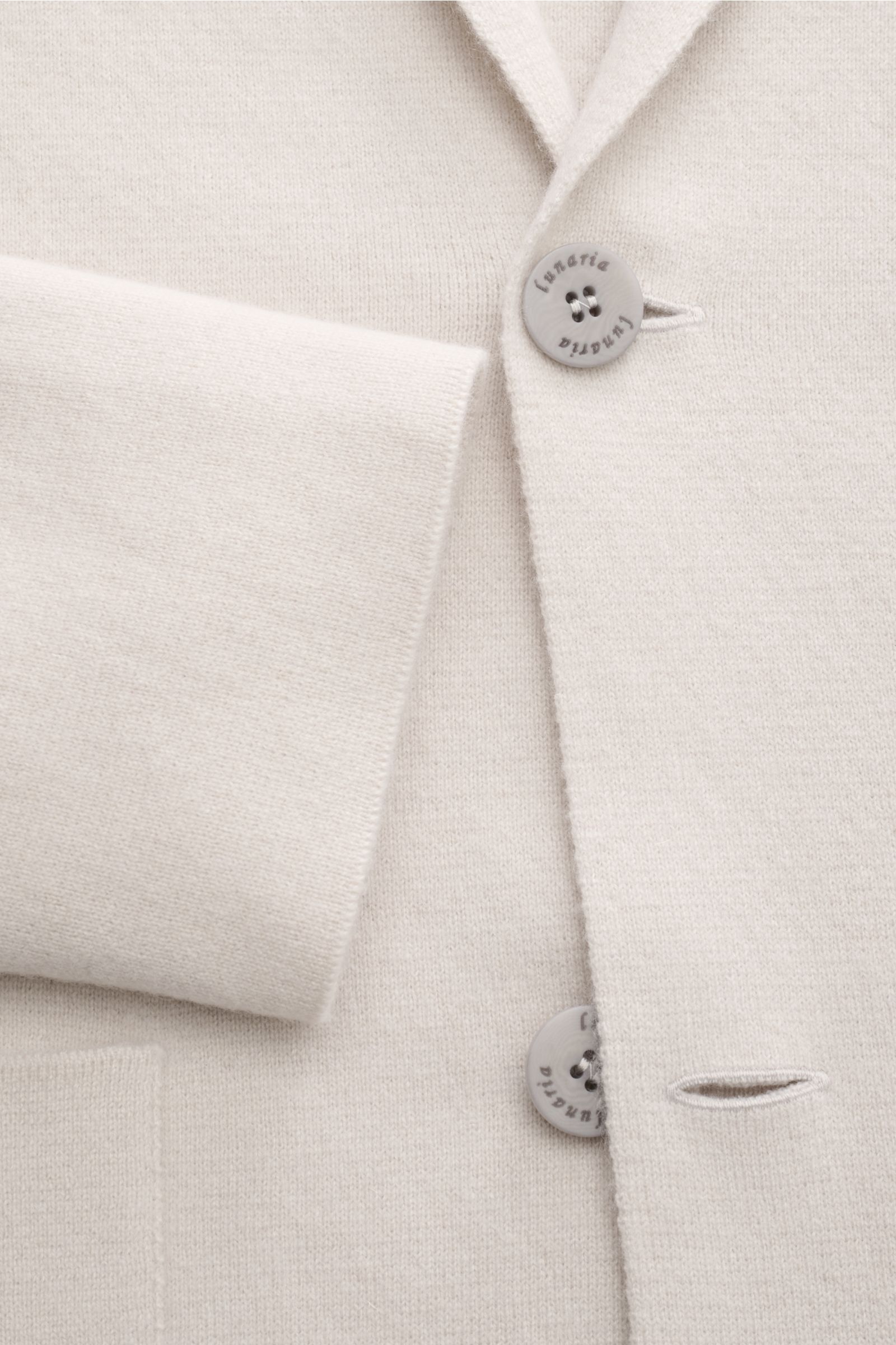 Nahaufnahme des Lunaria Cashmere Cashmere Cardigan sand mit Reverskragen, zwei Knöpfen und aufgesetzter Tasche, fein gestrickt.