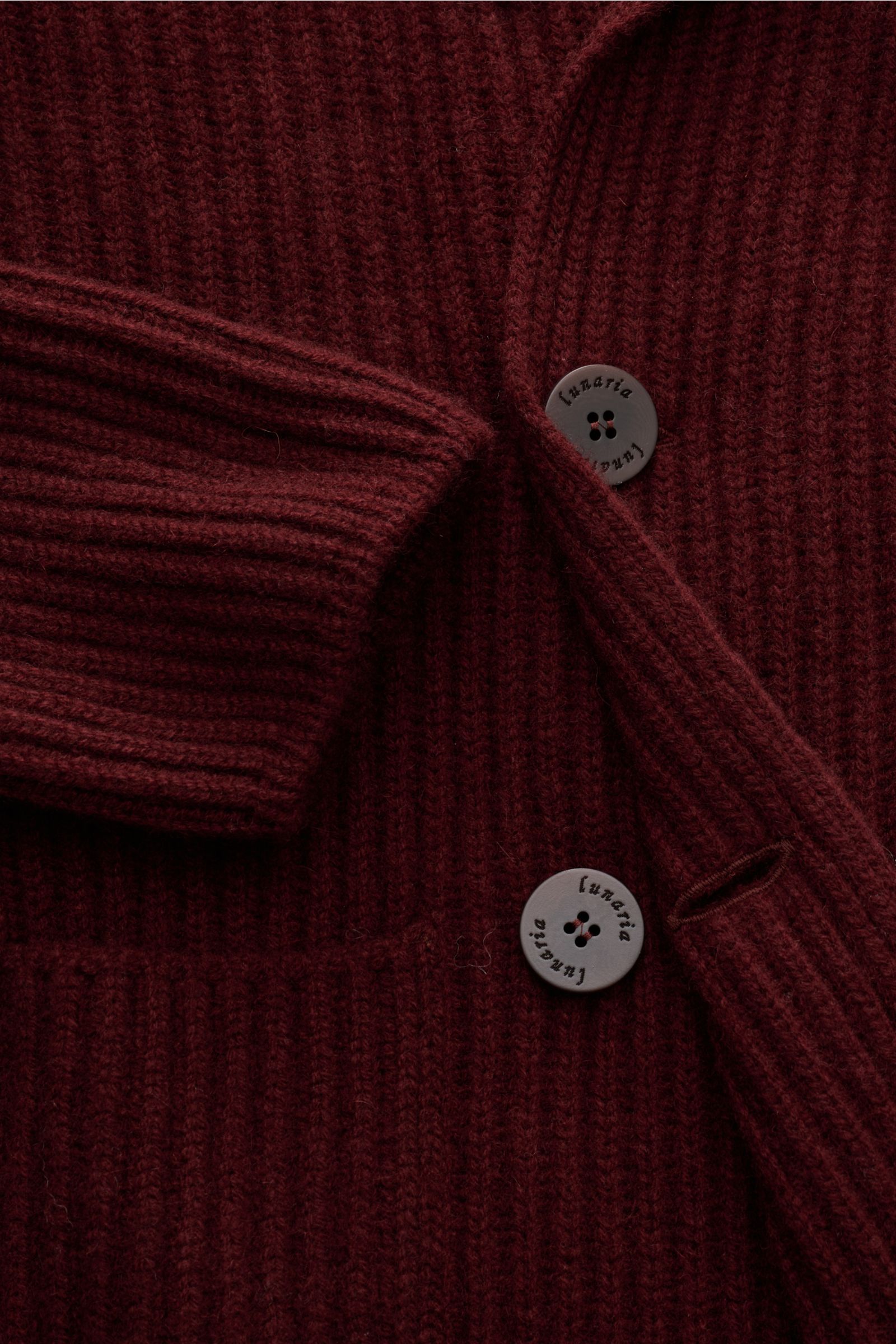 Nahaufnahme des Lunaria Cashmere Cashmere Cardigan bordeaux von schräg oben, weicher Strick mit voluminösem Patentmuster, Reverskragen und zweireihigen Knöpfen.