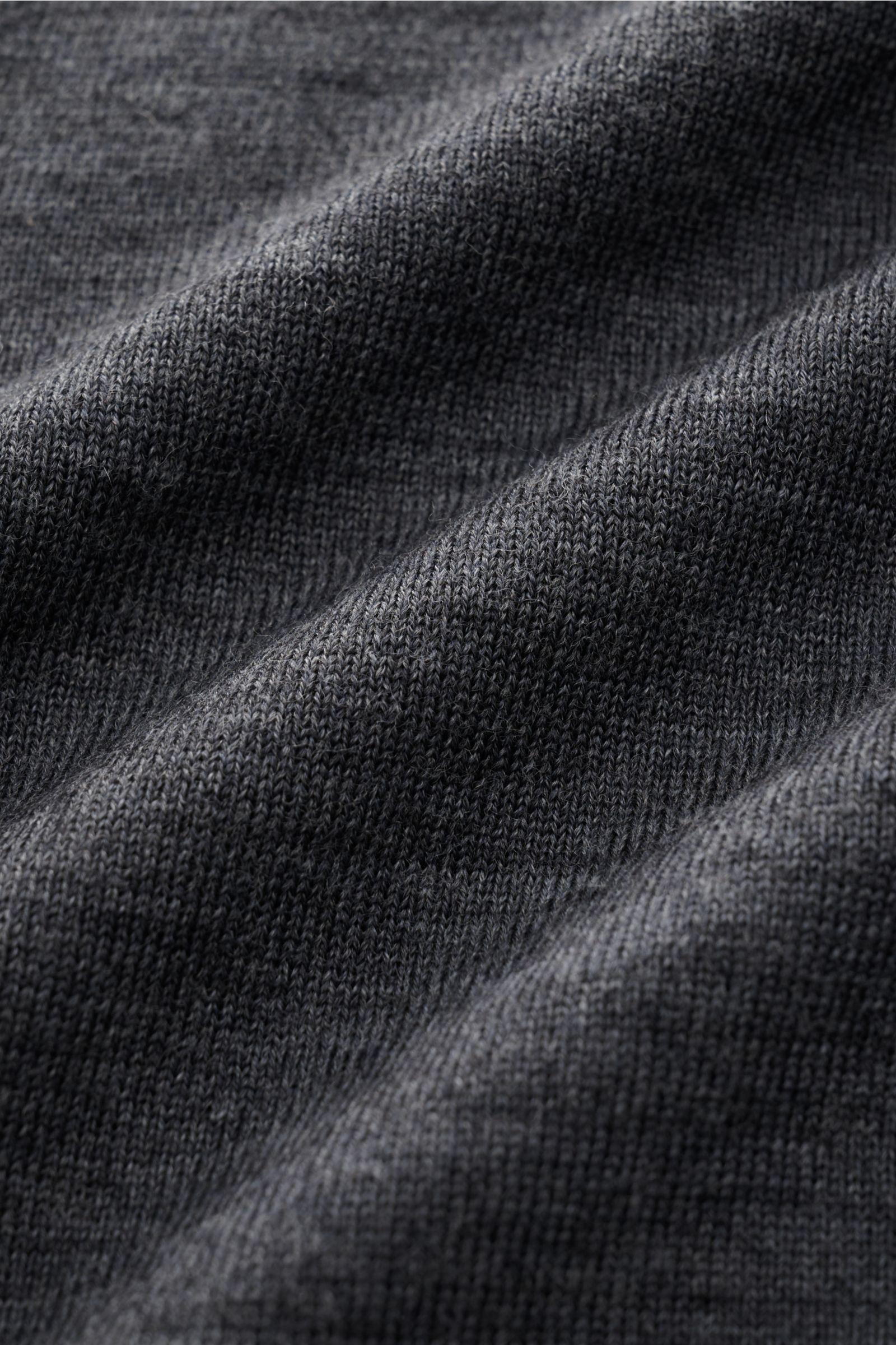 Close-up view of the dark gray melange fabric texture of the Closed Feinstrick-Cardigan dunkelgrau meliert, showing fine wool knit.

Description: Dieser CLOSED Cardigan in Feinstrick-Qualität wurde aus reiner Wolle gefertigt ist ein lässiges Layering-P