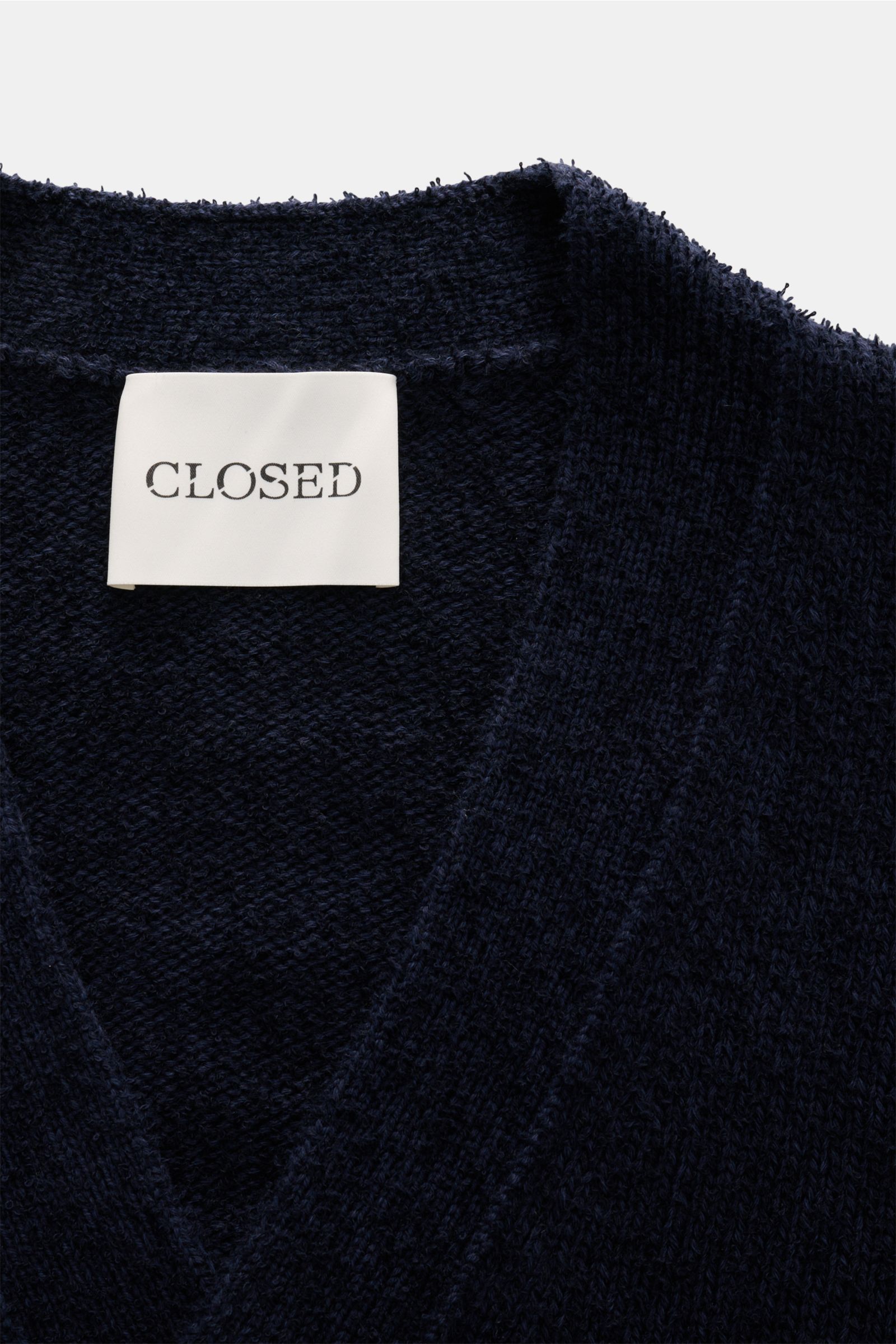 Close-up front view of the navy Closed Cardigan showing soft boucle knit, V-neck, and brand label inside the collar.

Description: Dieser relaxte Cardigan aus Baumwoll-Mix mit Wolle in Bouclé-Strick vom Hamburger Label CLOSED ist ein lässiger und styli