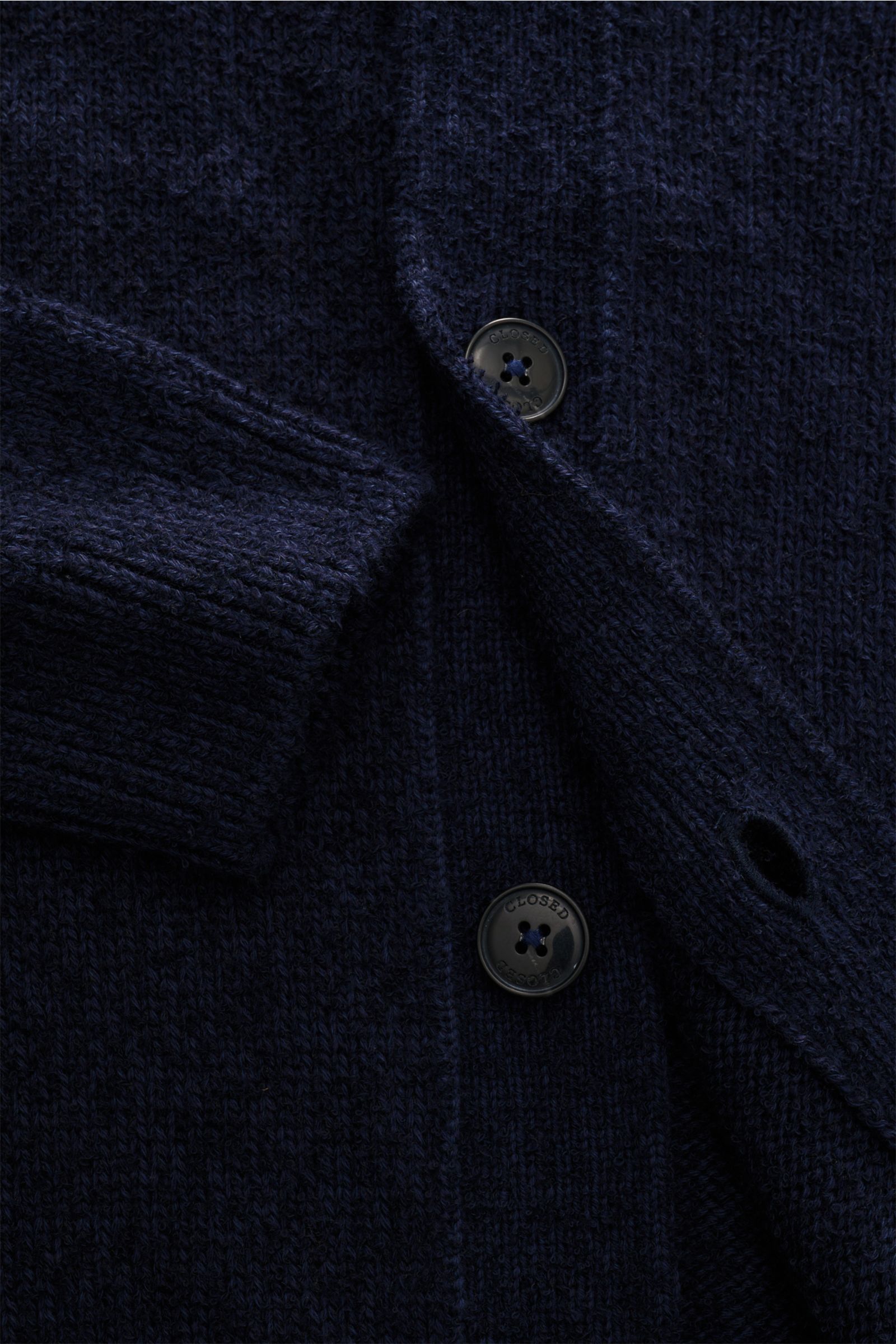 Close-up front view of Closed Cardigan navy showing textured bouclé knit in cotton-wool blend, raglan sleeve cuff, and four-button placket. 

Dieser relaxte Cardigan aus Baumwoll-Mix mit Wolle in Bouclé-Strick vom Hamburger Label CLOSED ist ein lässige