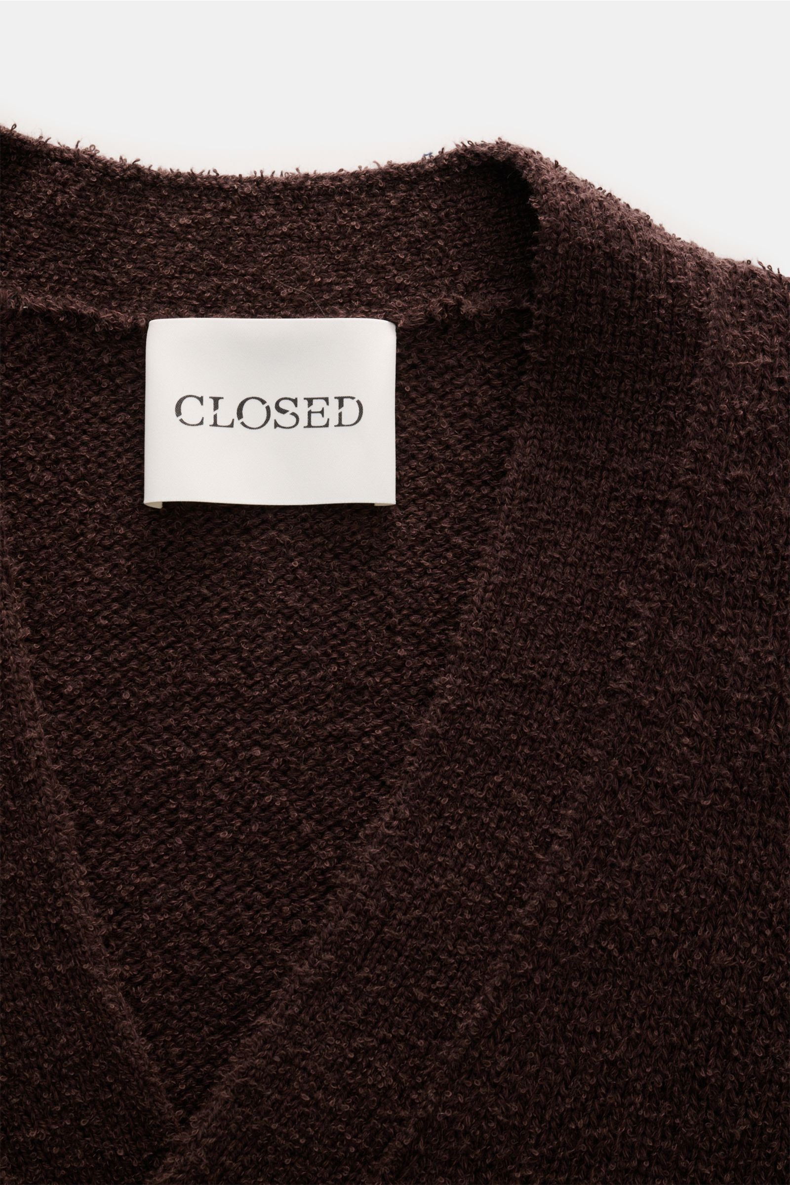 Close-up front view of Closed Cardigan dunkelbraun in boucle knit with cotton-wool blend, soft texture, and ribbed collar.

Description: Dieser relaxte Cardigan aus Baumwoll-Mix mit Wolle in Bouclé-Strick vom Hamburger Label CLOSED ist ein lässiger und