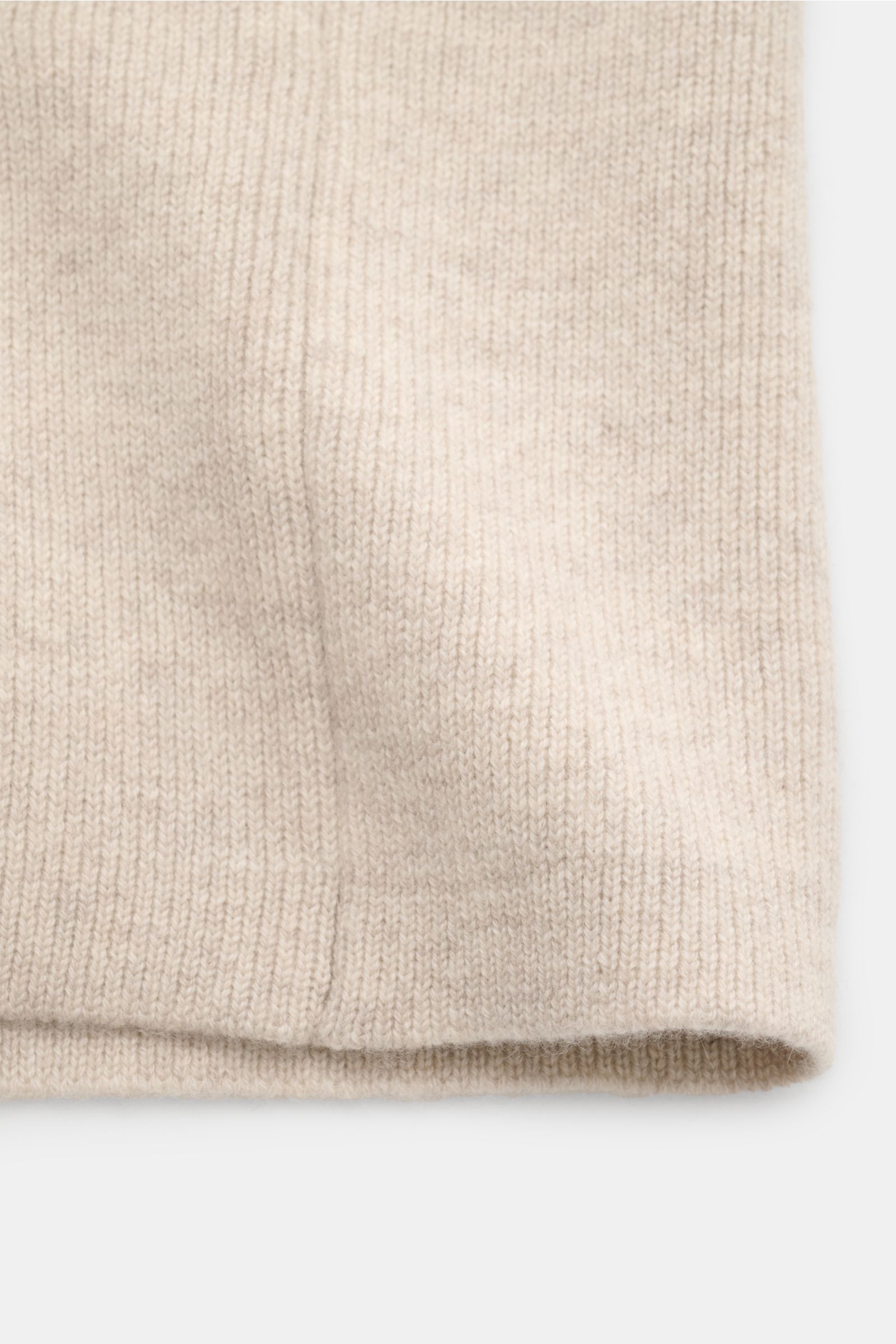 Close-up front view of the hem and knit texture of Lisa Yang Cashmere cardigan 'Louis' sand in fine, heavy cashmere fabric.