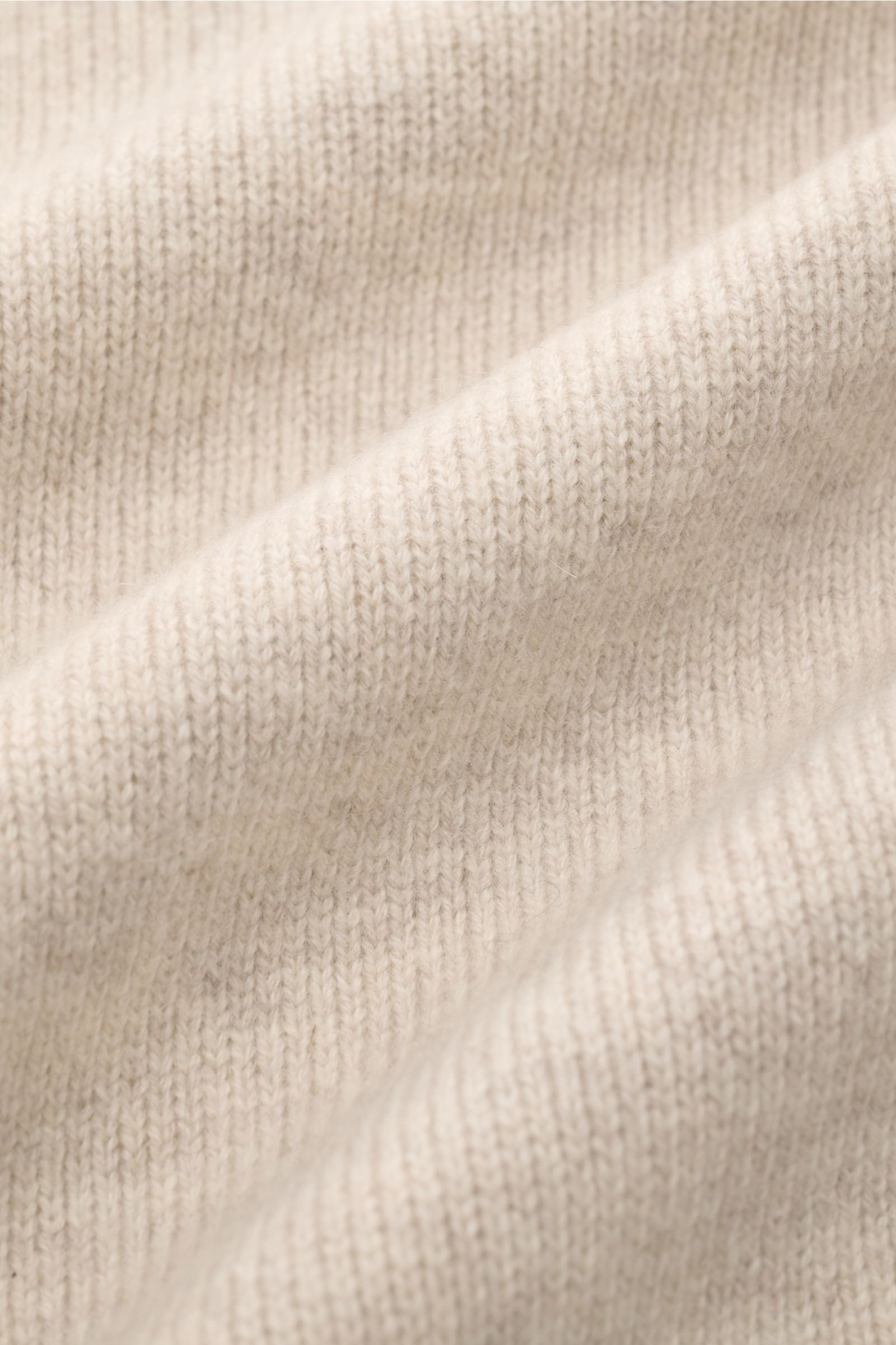 Close-up fabric detail of Lisa Yang Cashmere cardigan 'Louis' sand, showing medium-fine knit and soft, voluminous texture from a side angle. Scandinavian lines by LISA YANG: The cardigan 'Louis' is made of heavy fabric in fine cashmere and is an essential