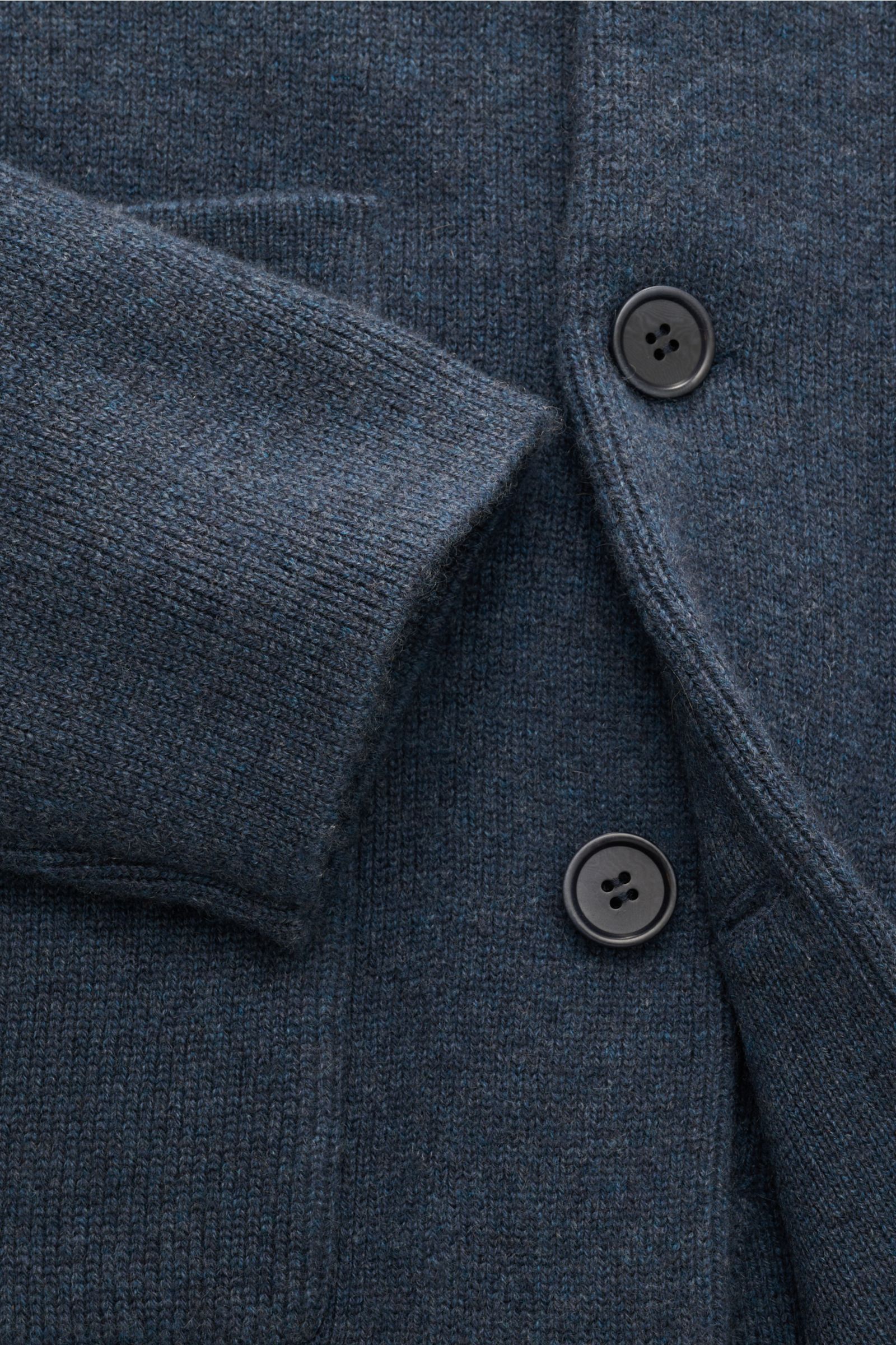 Close-up front view of Lisa Yang Cashmere cardigan 'Louis' grey-blue showing fine medium-knit fabric, buttons, cuff, and patch pocket. Scandinavian lines by LISA YANG: The cardigan 'Louis' is made of heavy fabric in fine cashmere and is an essential piece