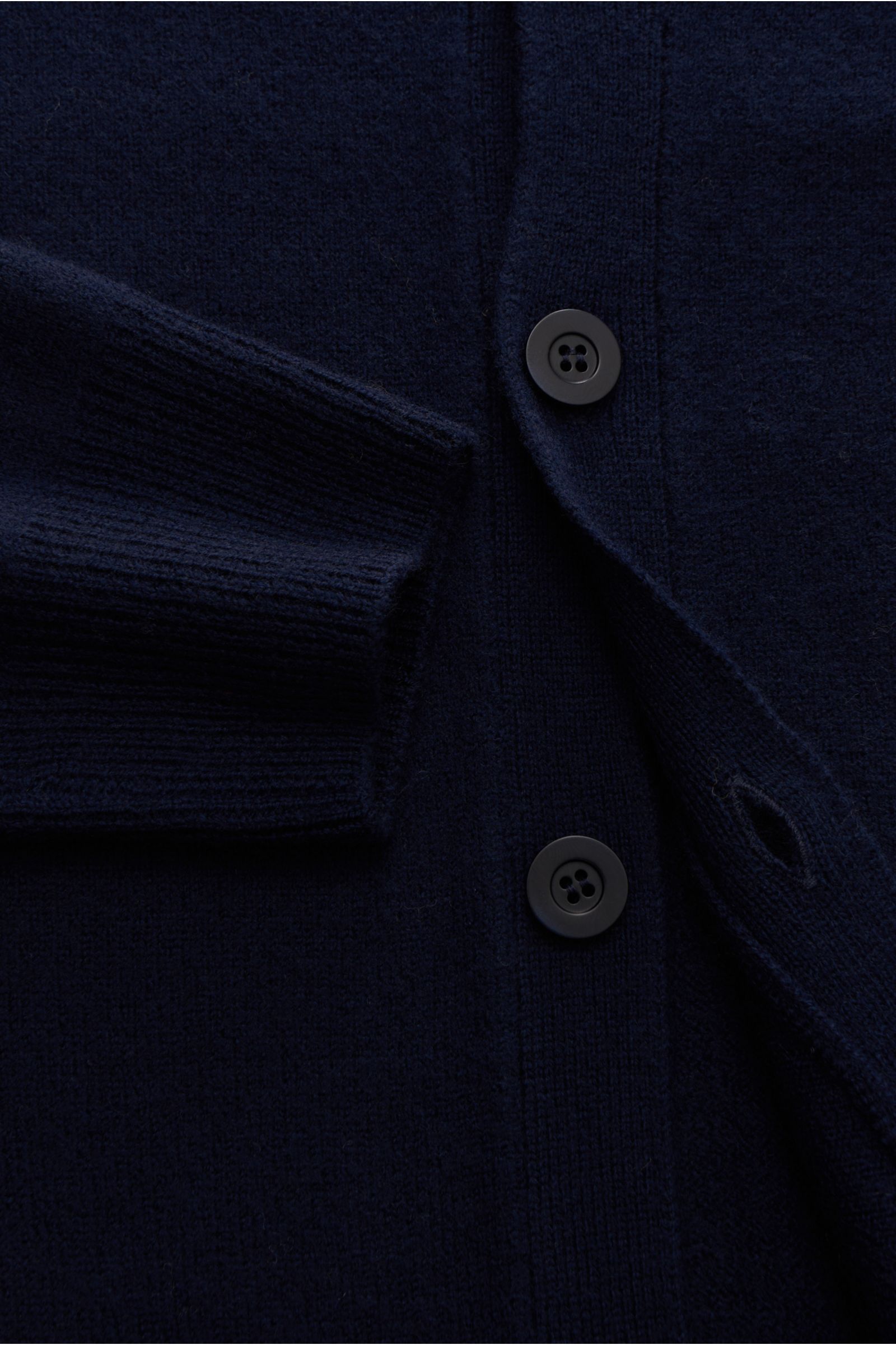 Nahaufnahme von A.P.C. Cardigan 'Kenny' navy mit reiner Wolle, weichem Griff, mittelfeinem Strickbild, Regular Fit, Fünf-Knopf-Leiste, flexiblen Rippbündchen und dezentem Logo.