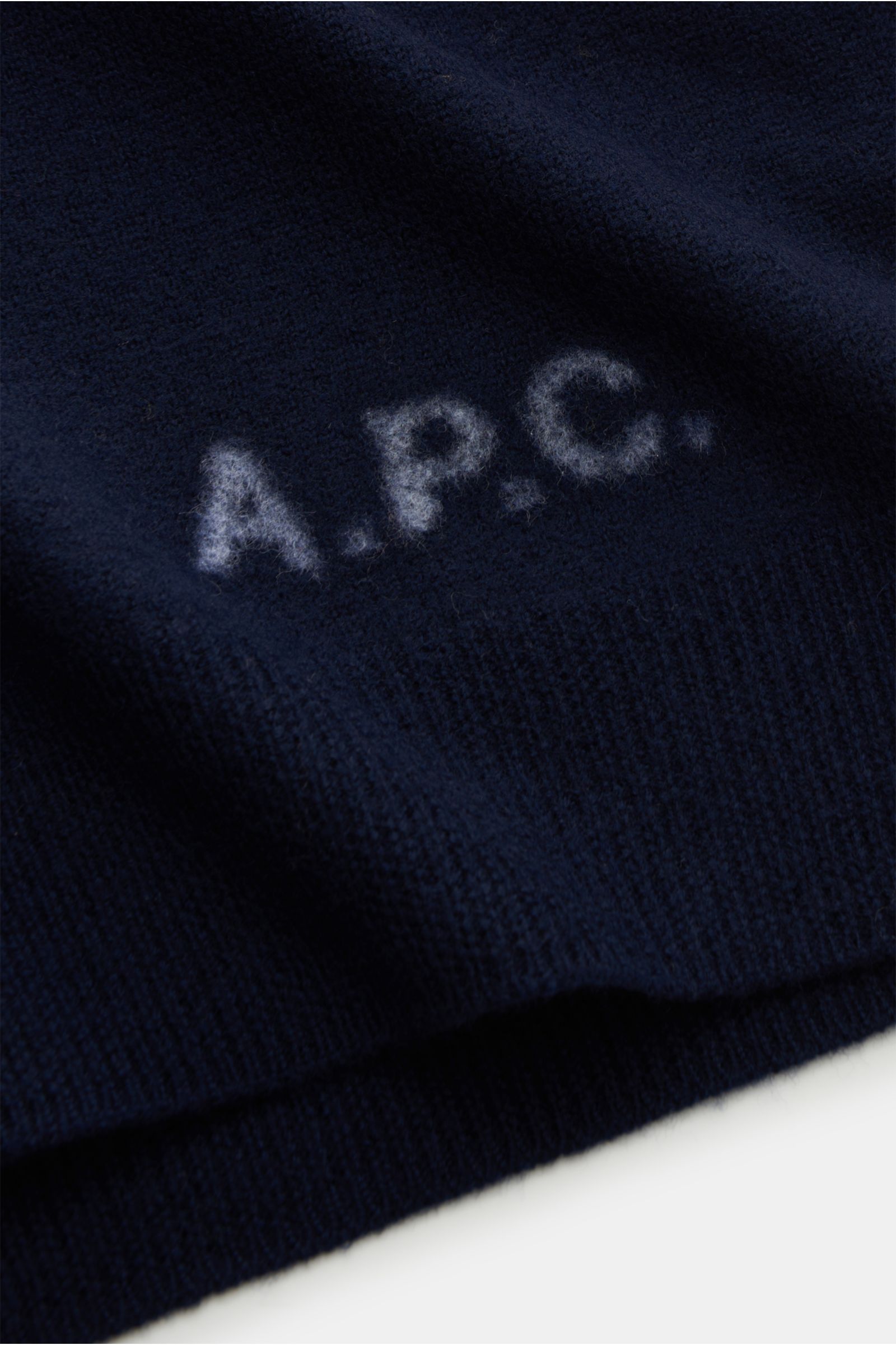 Nahaufnahme des A.P.C. Cardigan 'Kenny' navy mit dezentem Logo, reiner Wolle, weichem Griff, mittelfeinem Strickbild, Regular Fit, Fünf-Knopf-Leiste und flexiblen Rippbündchen.