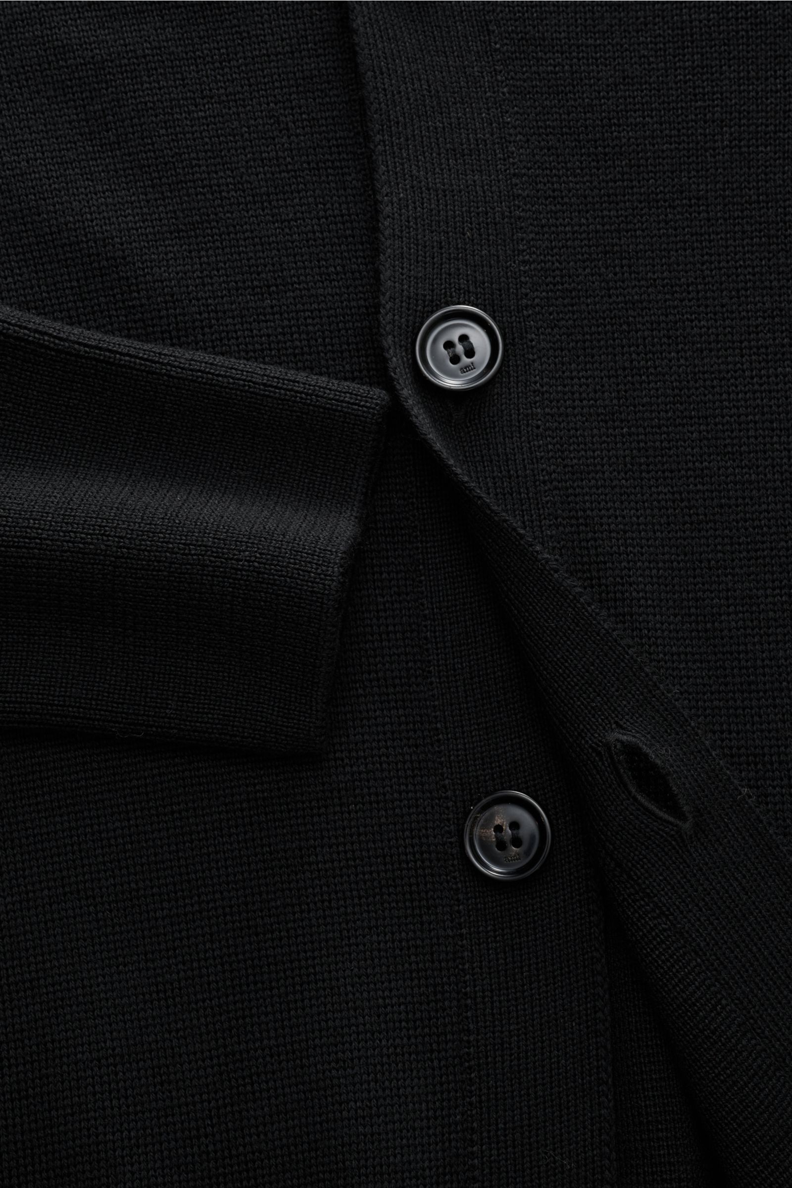 Ami Paris Merino Cardigan schwarz aus feiner Merinowolle, V-Ausschnitt, fünf Knöpfe, elastische Rippbündchen, Detailaufnahme von vorne.