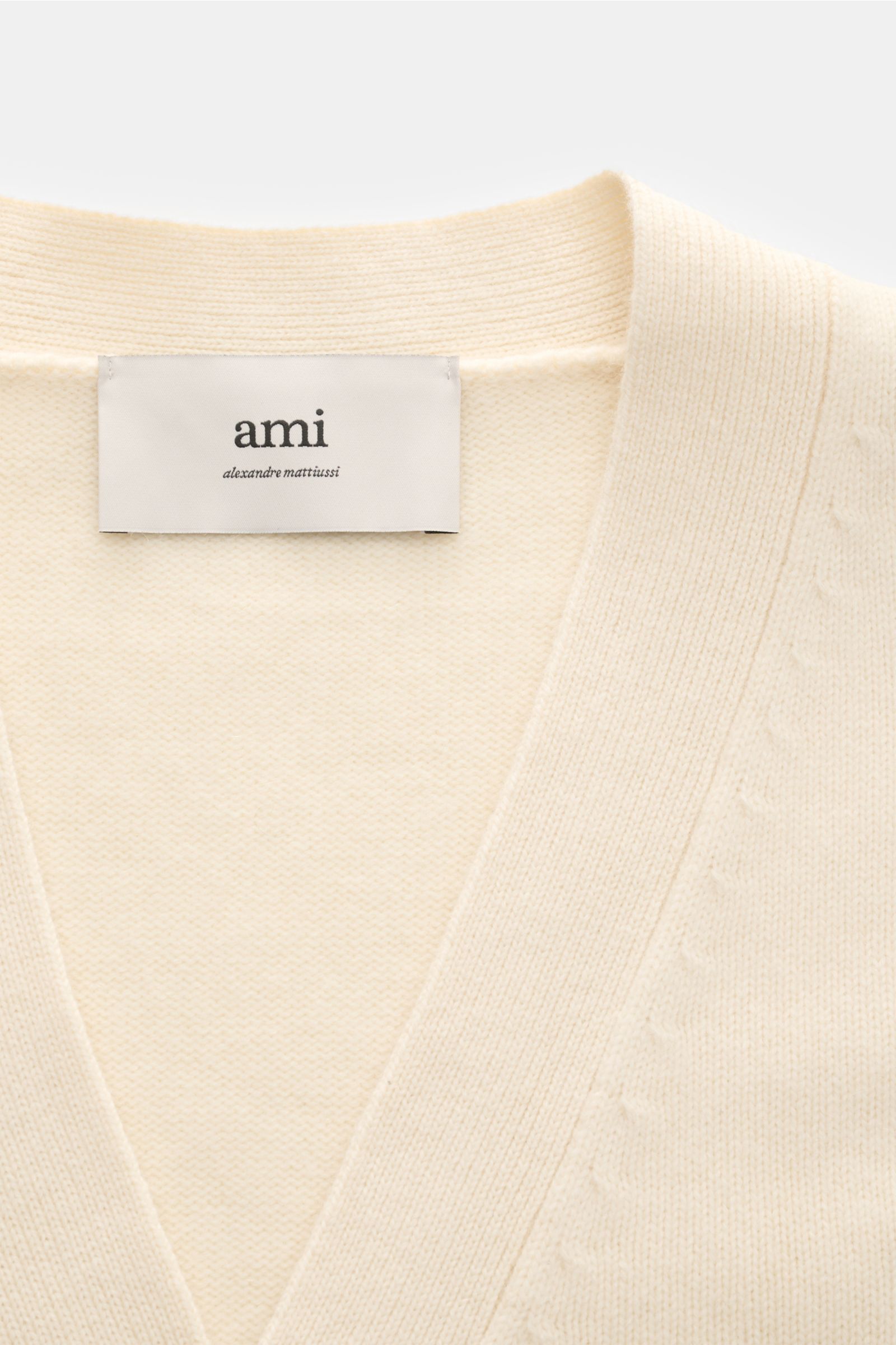 Close-up front view of Ami Paris Cardigan cream showing the V-neck, soft wool and cashmere knit, and label.

A monochrome favourite from AMI PARIS: This iconic cardigan with signature quilted 'Ami' logo is made of wool and cashmere – the perfect blend 