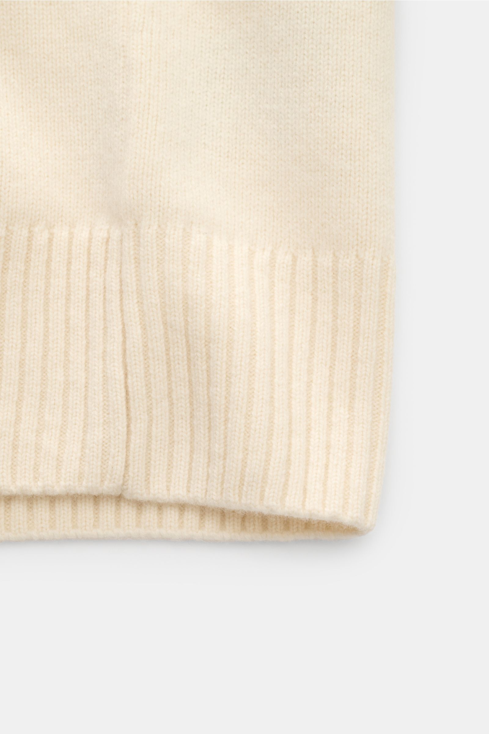 Nahaufnahme des unteren Saums vom Ami Paris Cardigan creme, gestrickt aus Wolle und Cashmere mit breiten, elastischen Rippbündchen.
