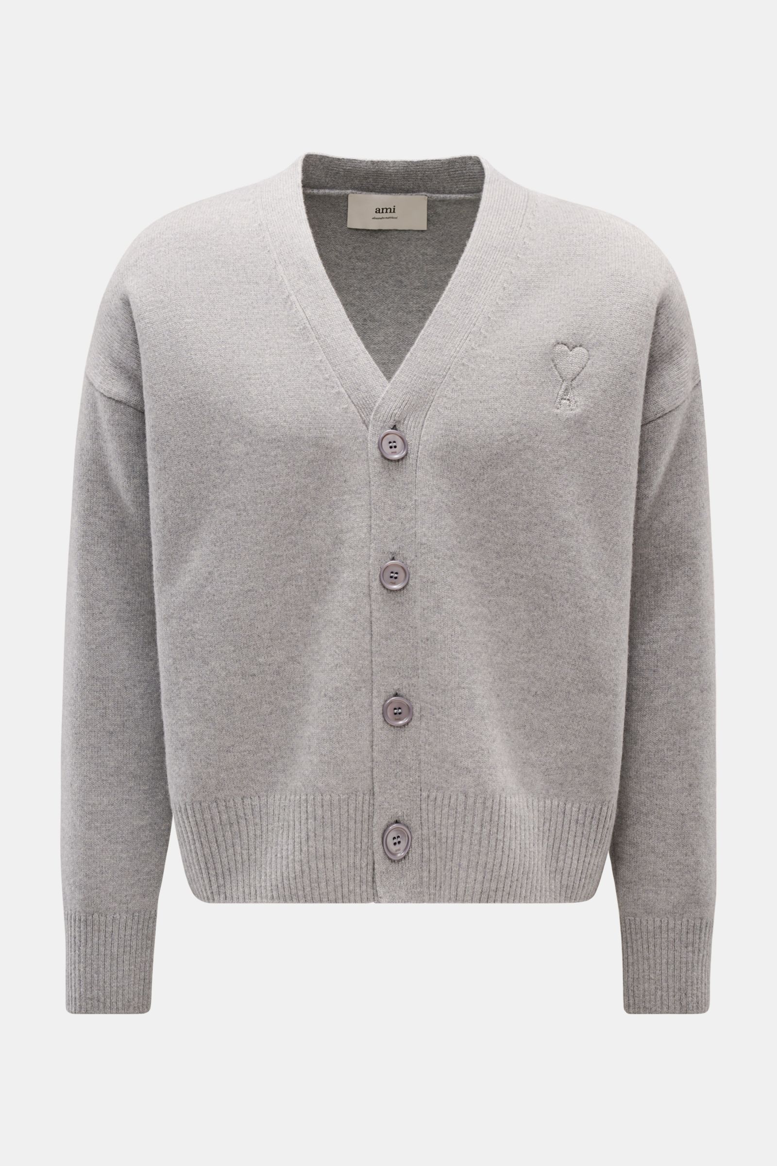 Front view of Ami Paris Cardigan grau in light grey, made from soft wool and cashmere with a V-neck, four-button placket, oversized fit, ribbed cuffs, and stitched Ami heart logo.

Description: Monochromes Lieblings-Piece von AMI PARIS: Der ikonische C
