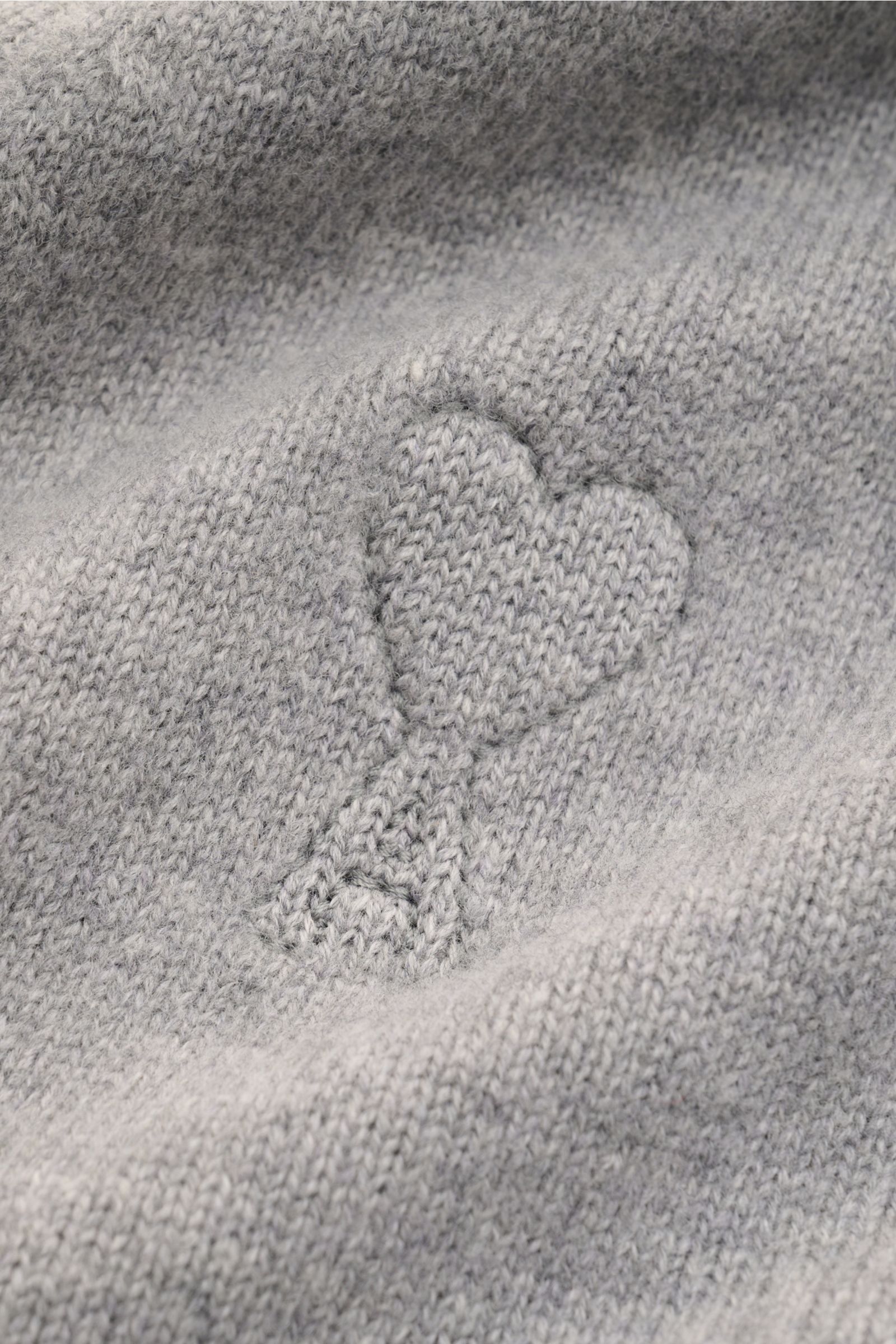 Close-up front view of the Ami Paris Cardigan grau showing the soft wool and cashmere knit and the embossed heart logo detail.

Monochromes Lieblings-Piece von AMI PARIS: Der ikonische Cardigan mit typisch abgestepptem 'Ami'-Logo wurde aus Wolle und Ca