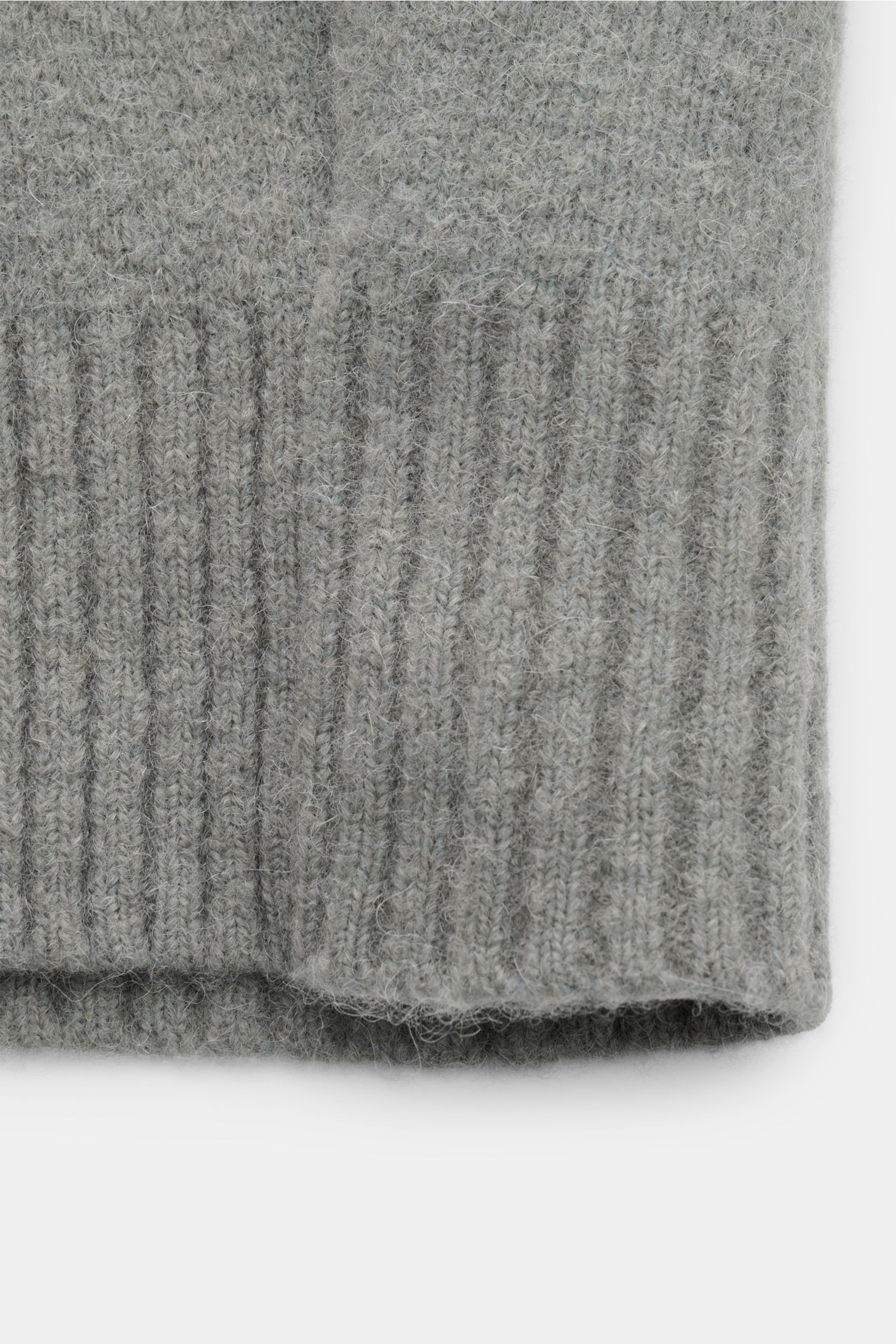 Nahaufnahme des unteren Saums und breiter Rippbündchen des Ami Paris Cardigan grau aus elastischem Alpaka-Woll-Strick, voluminös, weich.