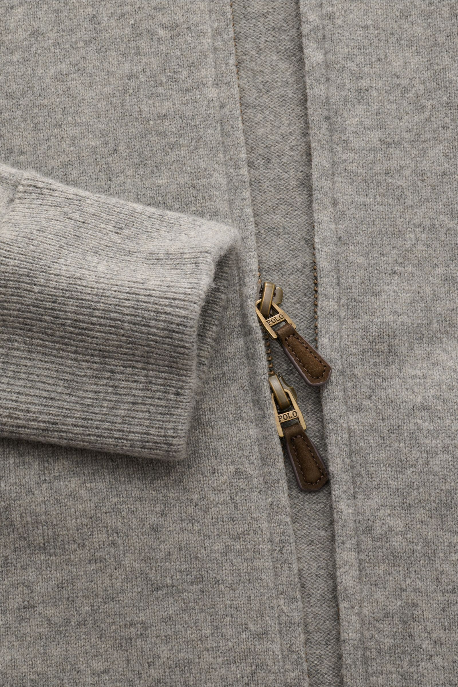 Nahaufnahme der Polo Ralph Lauren Strickjacke grau meliert aus weicher, reiner Wolle mit feinem Strickbild, Rippbündchen und Zwei-Wege-Reißverschluss.