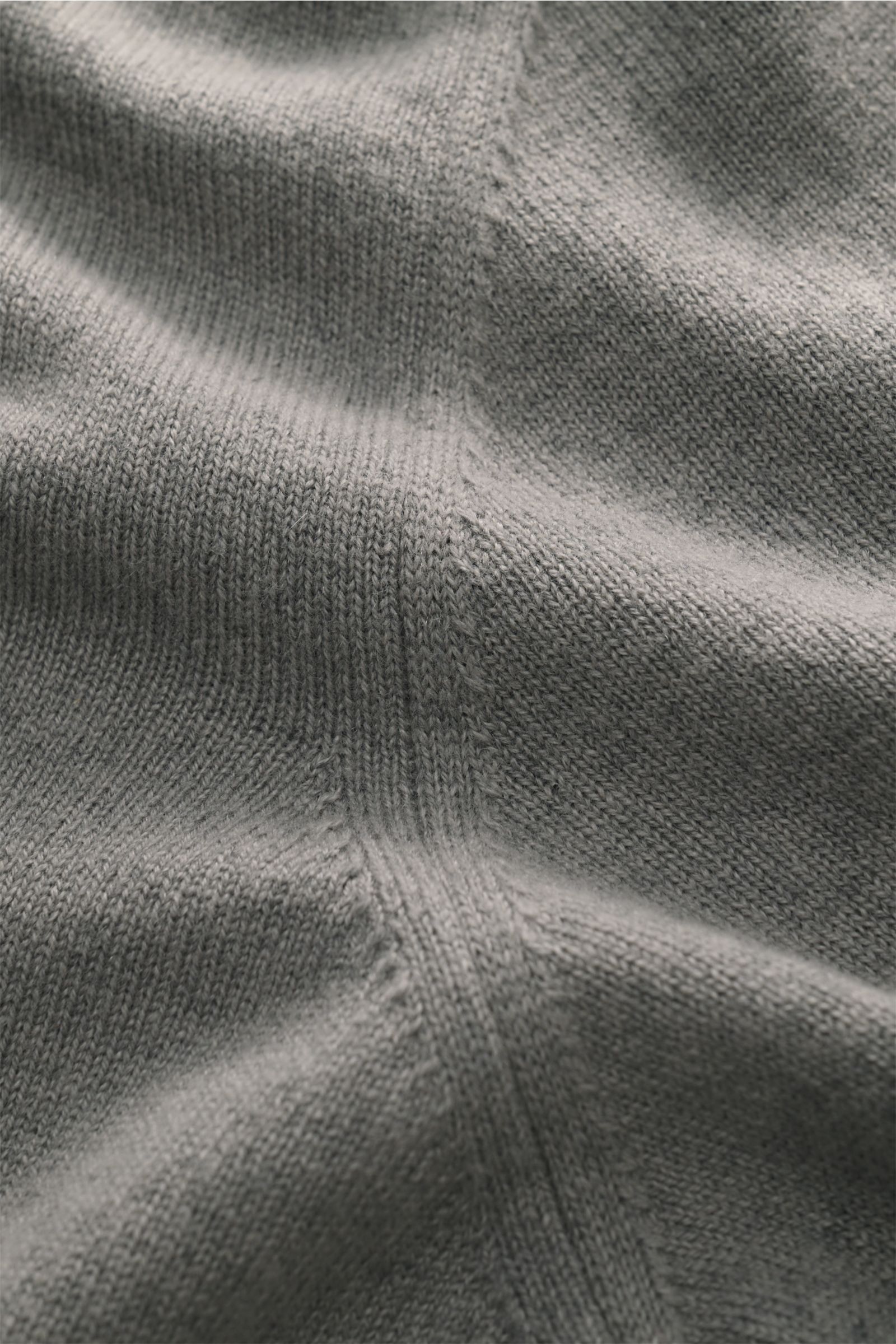 Nahaufnahme des feinen Strickbilds der Colombo Cashmere Strickjacke grau aus reiner Kid Cashmere, weicher Griff, Slim Fit mit Stehkragen, Zwei-Wege-Reißverschluss, Horn-Pull-Tabs und flexiblen Rippbündchen, leichte Qualität.