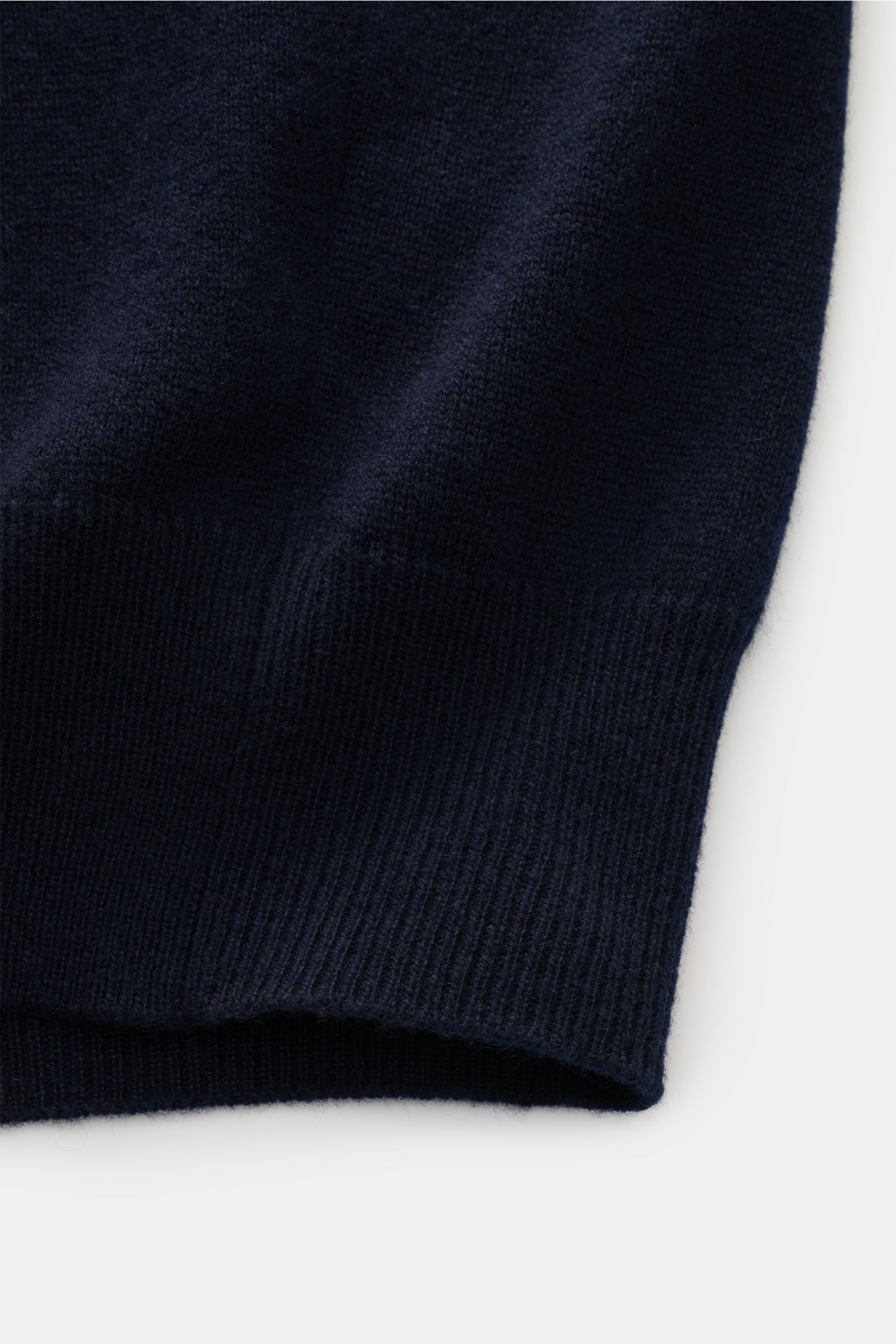 Nahaufnahme von der unteren Kante der Colombo Cashmere Strickjacke navy, reiner Kid Cashmere, weicher Griff, sehr feines Strickbild, leichte Qualität, Slim Fit, anliegender Stehkragen, feiner Zwei-Wege-Reißverschluss mit Pull-Tabs aus Horn, flexible Rippb