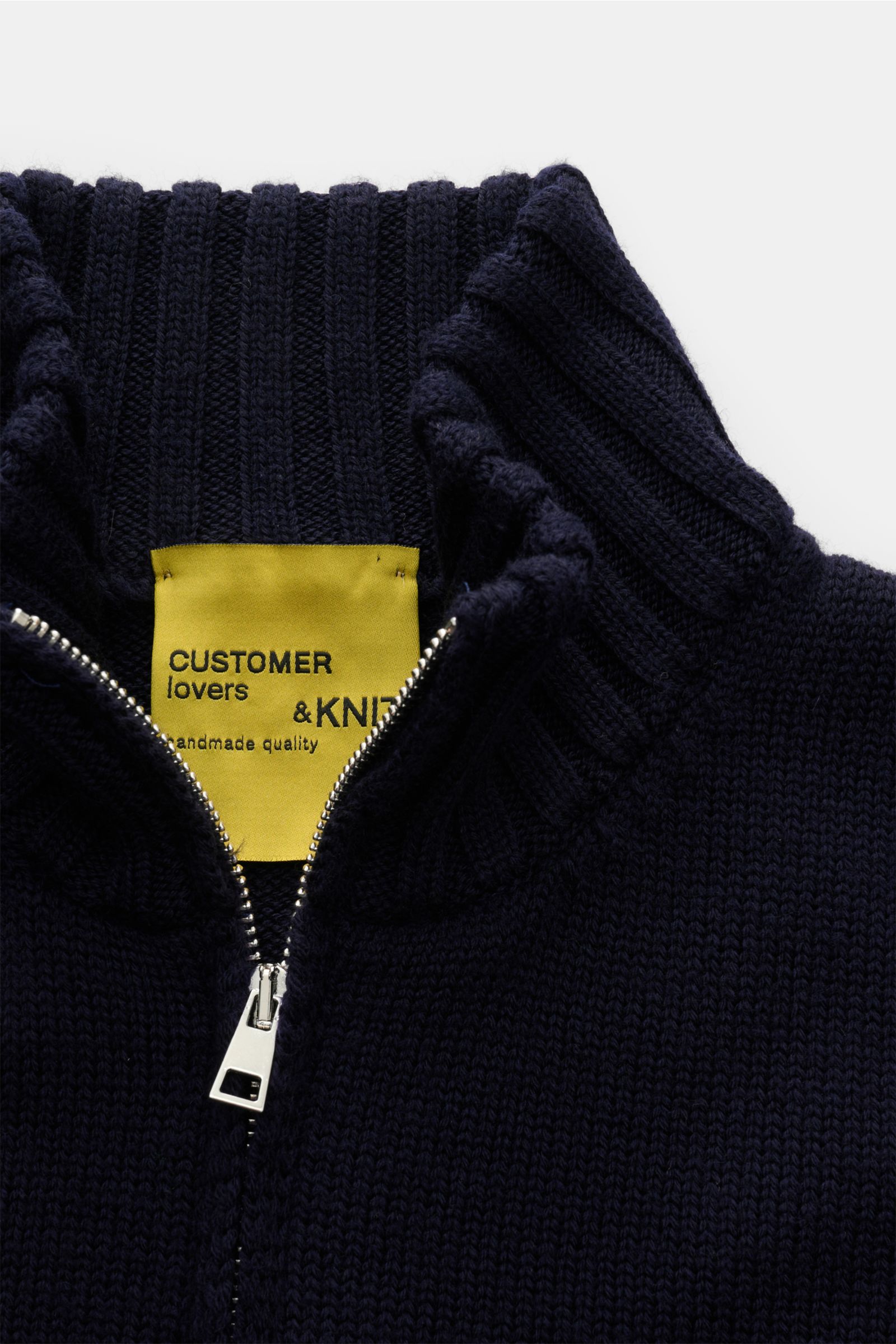 Close-up view of the B.F. Knitwear Merino Strickjacke navy, showing its high ribbed stand-up collar, two-way zipper, and soft merino wool texture. Hochwertiger Allrounder für kühle Tage: Die Strickjacke von B.F. KNITWEAR aus geschmeidiger Merinowolle mit 
