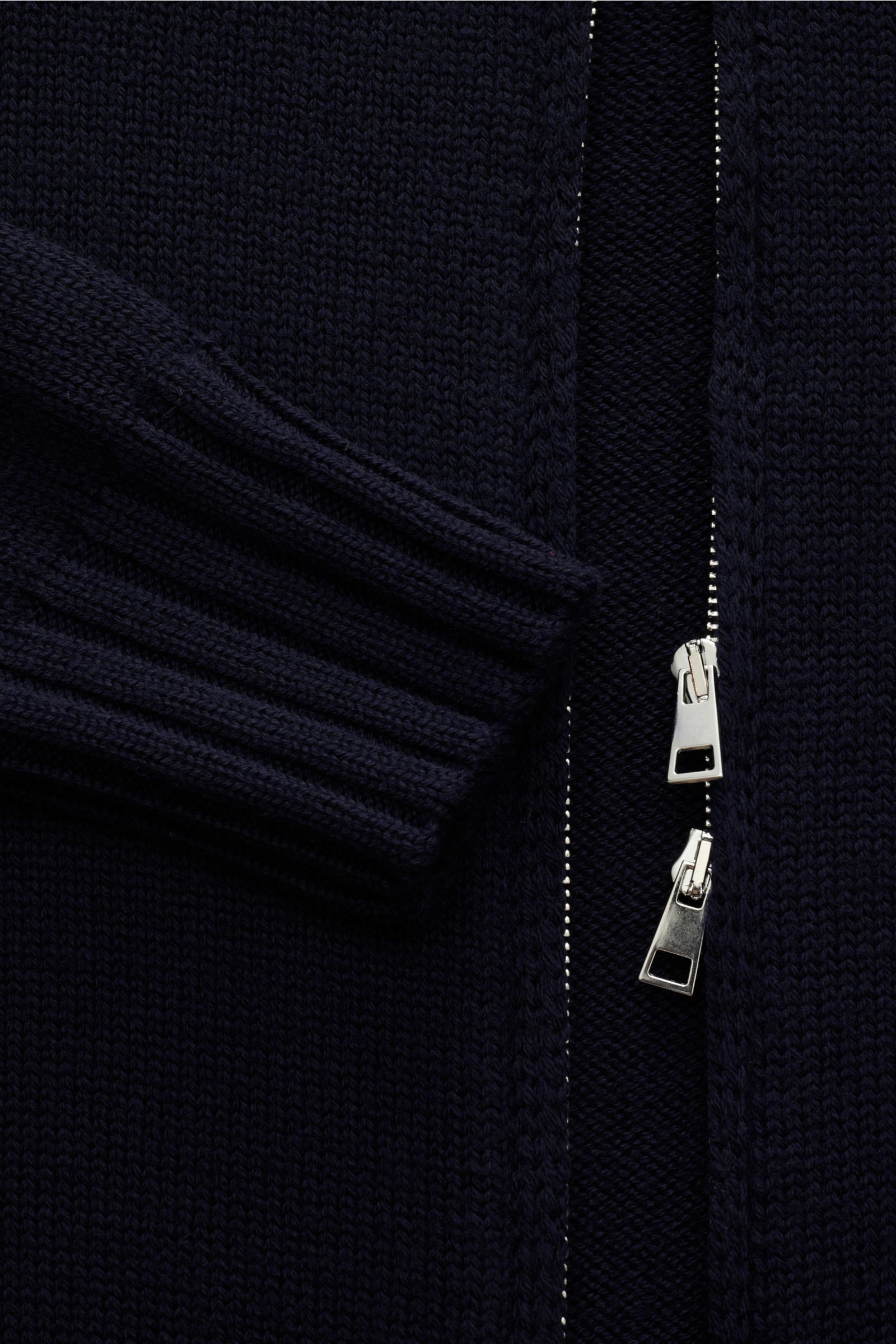 Close-up front view of B.F. Knitwear Merino Strickjacke navy showing soft pure merino wool knit, slim fit, ribbed cuffs, standing collar, and two-way silver zipper. Hochwertiger Allrounder für kühle Tage: Die Strickjacke von B.F. KNITWEAR aus geschmeidige