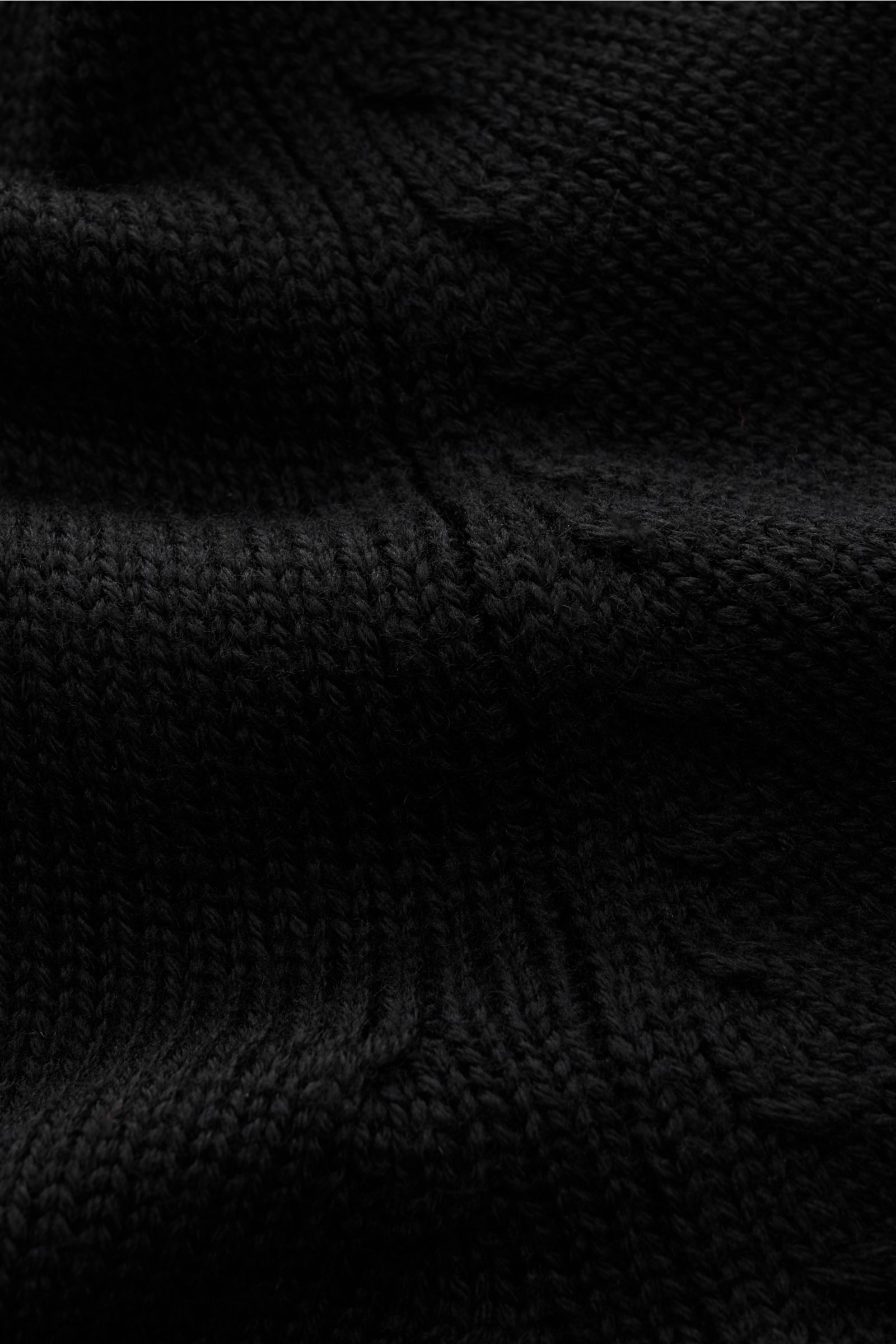 B.F. Knitwear Merino Strickjacke schwarz, Nahaufnahme des mittelgroben Strickbilds aus reiner Merinowolle mit Stehkragen und Rippbündchen.