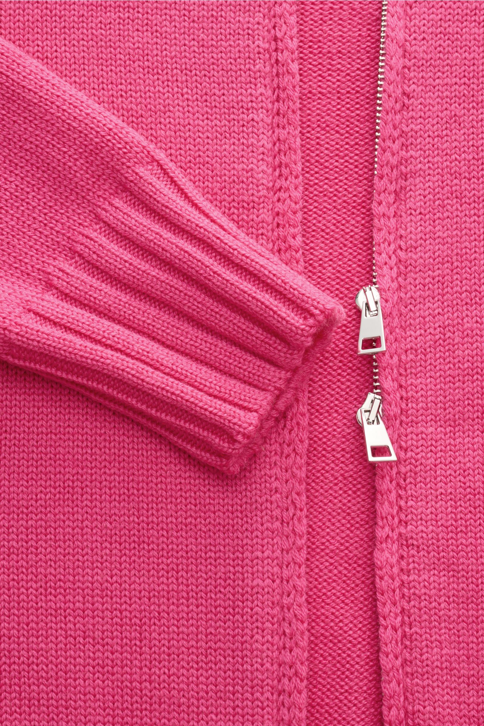 Nahaufnahme der B.F. Knitwear Merino Strickjacke magenta von oben, zeigt weichen Griff, mittelgrobes Strickbild, Slim Fit, Zwei-Wege-Reißverschluss, Stehkragen, Rundhalsausschnitt und komfortable Rippbündchen aus reiner Merinowolle.