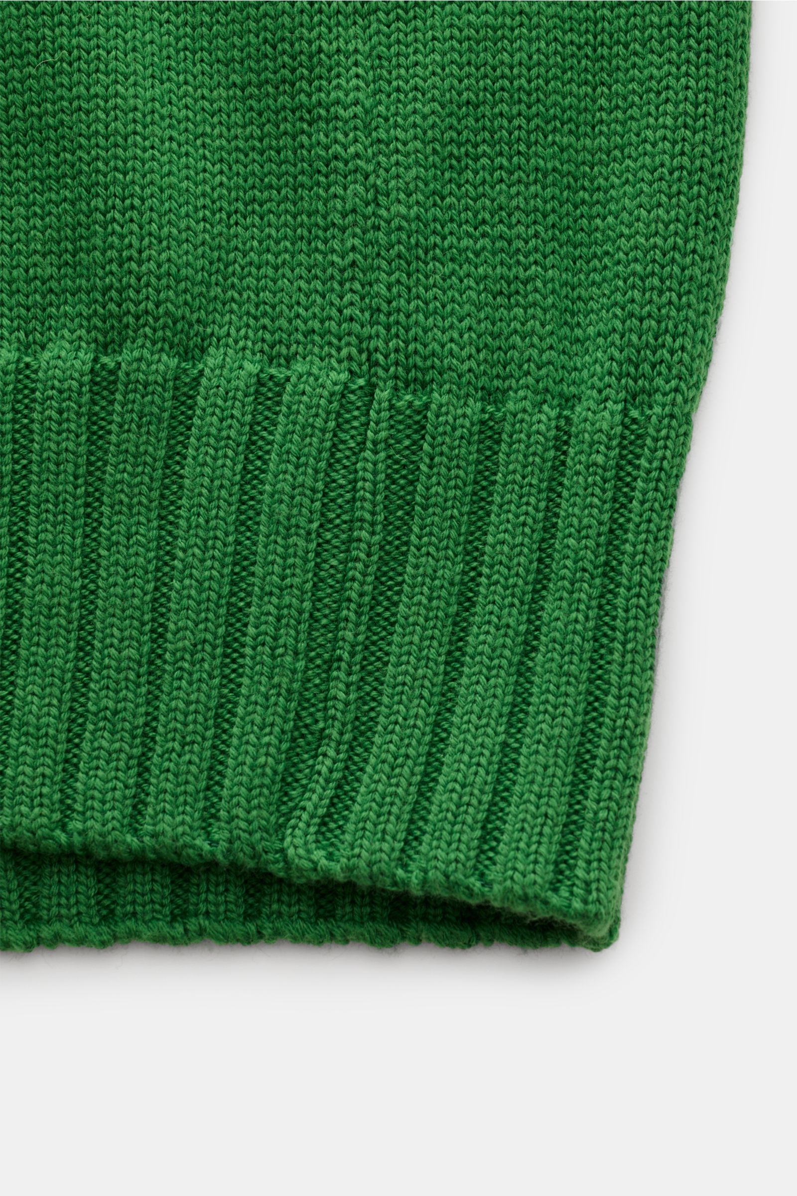 Nahaufnahme der grünen B.F. Knitwear Merino Strickjacke, Detailansicht des weichen, mittelgroben Strickbilds mit Rippbündchen.