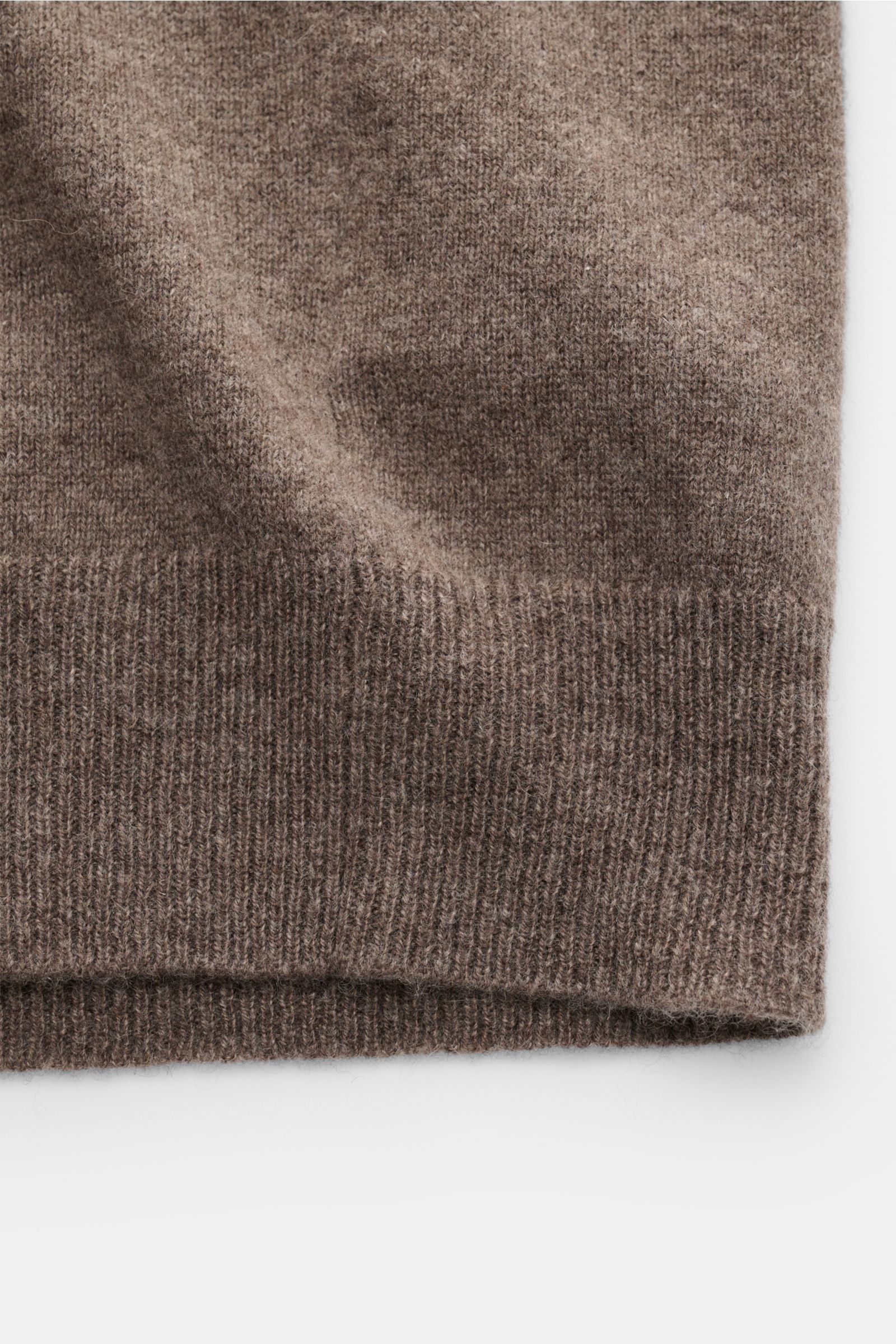 Nahaufnahme der FTC Cashmere Strickjacke graubraun von unten, feines Strickbild, weicher Griff, gerippter Saum, Fair-Trade-Cashmere, Slim Fit.