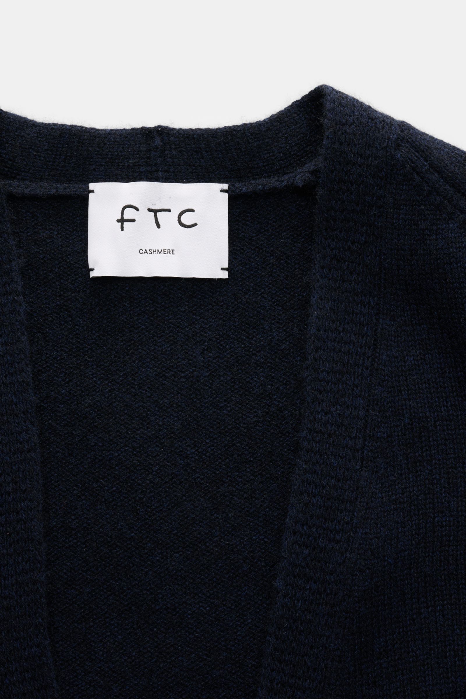 Nahaufnahme des FTC Cashmere Cardigan navy von oben mit V-Ausschnitt, mittelfeinem Strickbild und weichem Fair-Trade-Cashmere.