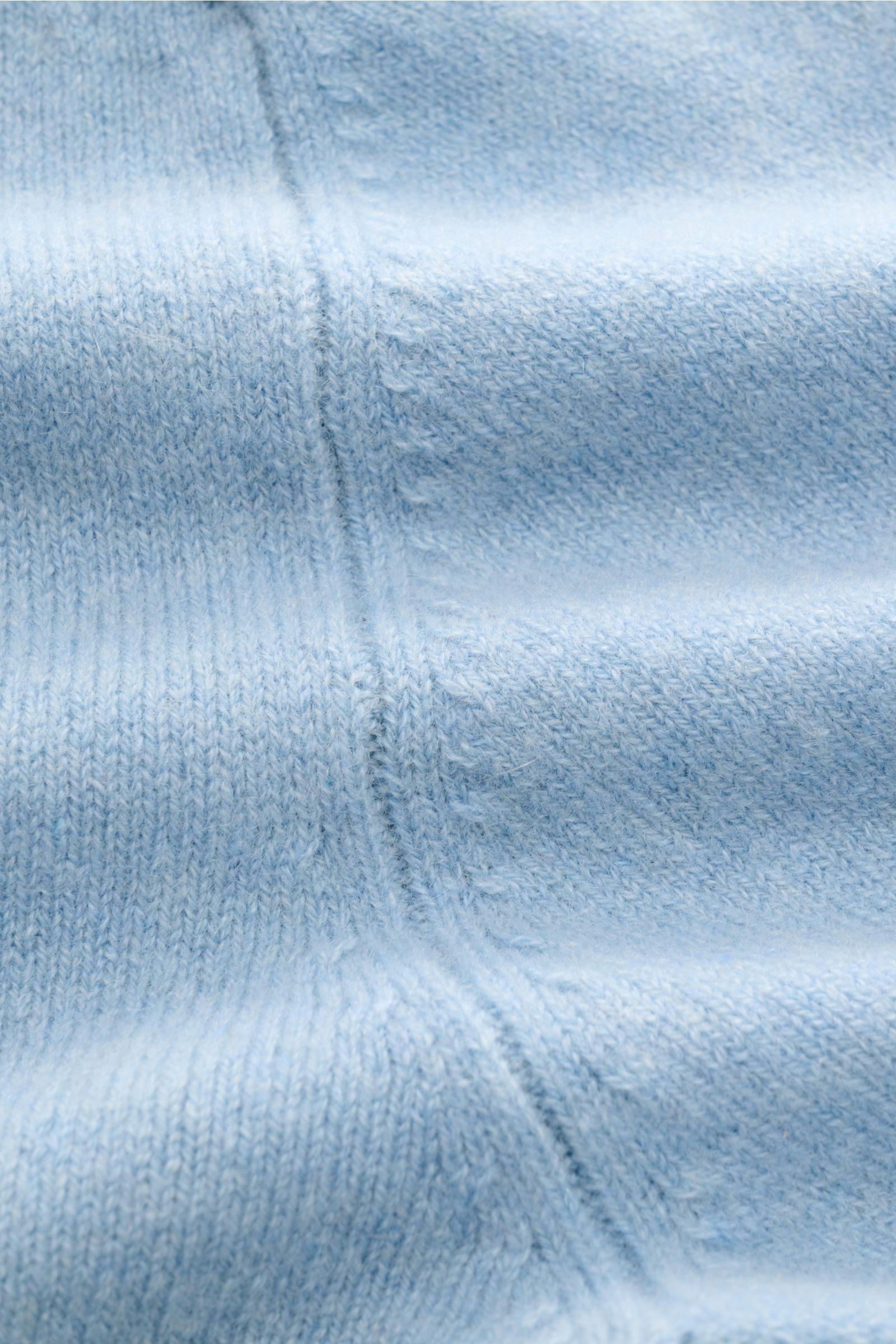 Nahaufnahme des mittelfeinen Strickbilds vom FTC Cashmere Cardigan hellblau aus Fair-Trade-Cashmere, Detail der Naht und weichen Struktur.
