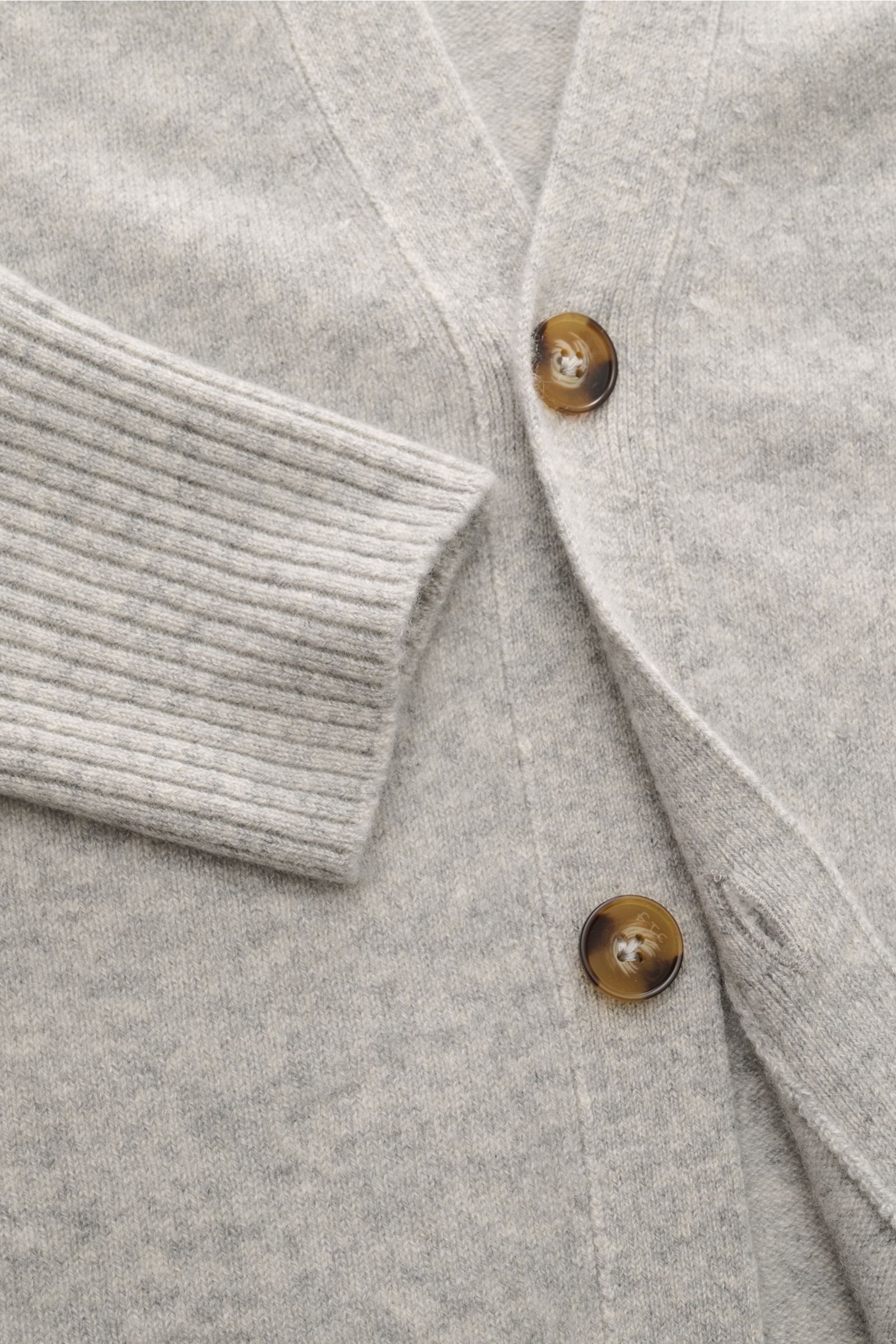 Nahaufnahme des FTC Cashmere Cardigan grau meliert von vorne mit V-Ausschnitt, Vier-Knopf-Leiste und elastischem, mittelfeinem Strick aus Fair-Trade-Cashmere.