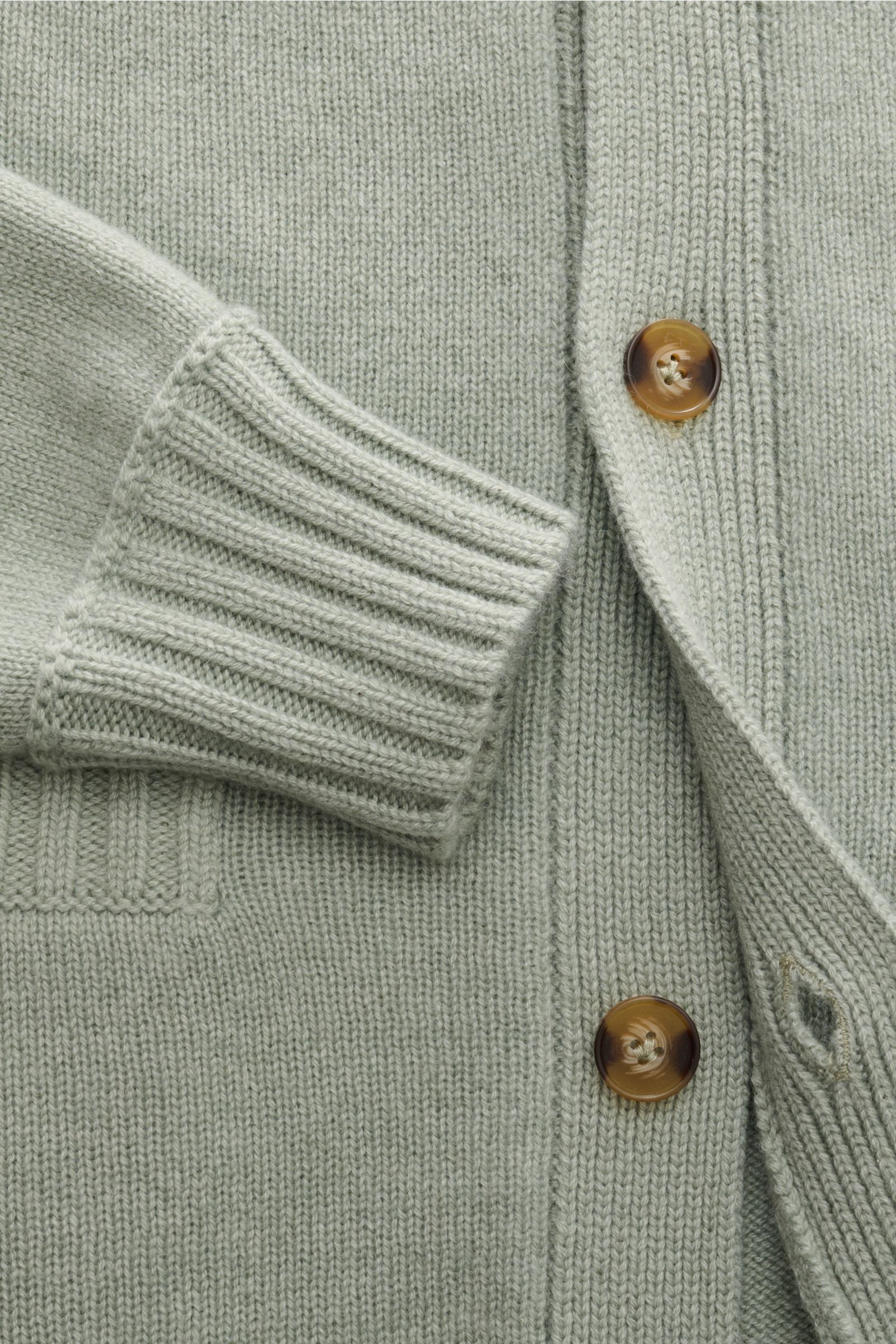 FTC Cashmere Cardigan graugrün aus reiner Fair-Trade-Cashmere in Nahaufnahme von Ärmel, Leistentasche, Rippbündchen und Knopfleiste.