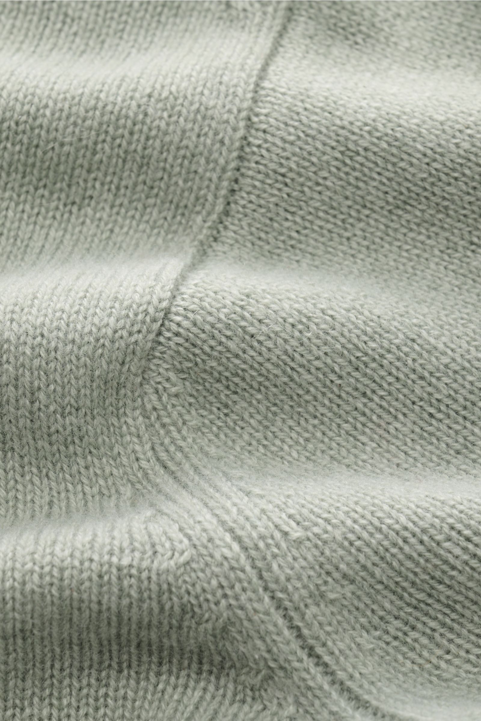 Nahaufnahme des FTC Cashmere Cardigan graugrün aus reinem Fair-Trade-Cashmere mit mittelfeinem Strickbild, weichem Griff und Rippbündchen.