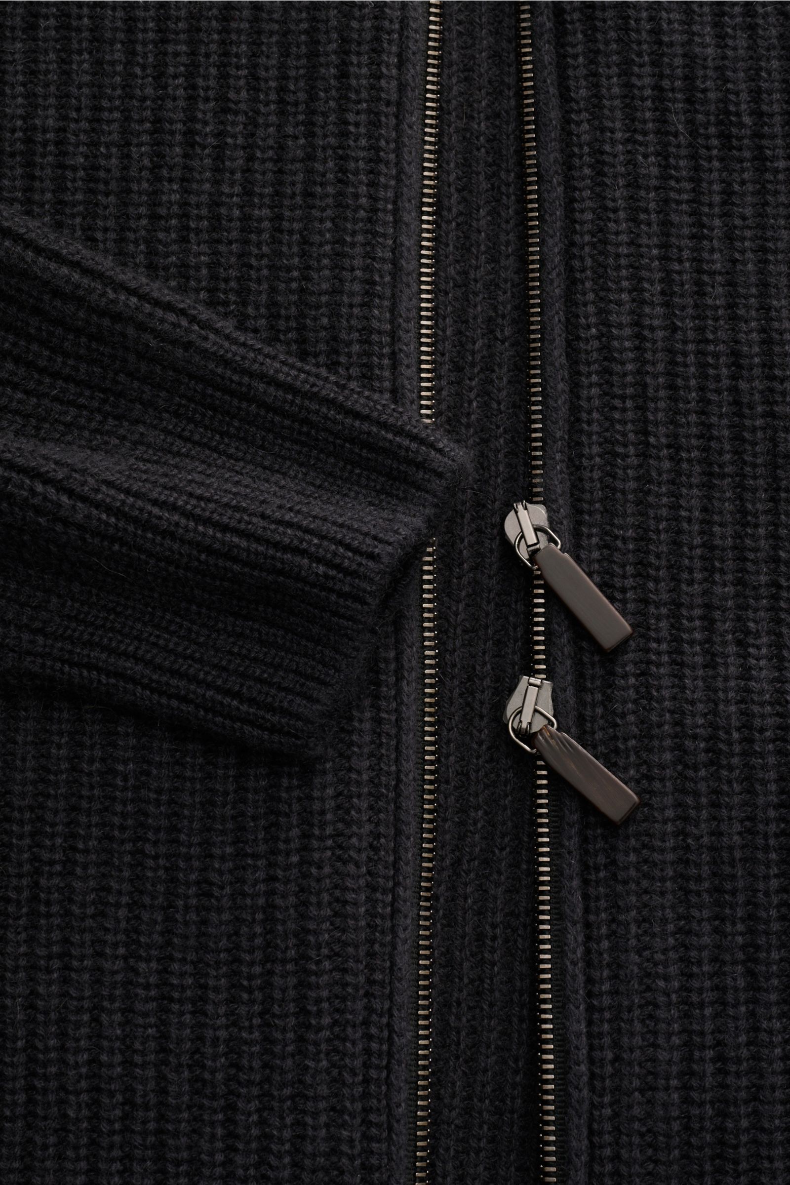 Close-up front view of the Iris von Arnim Uomo Cashmere Strickjacke 'Curt' dunkelgrau, showing its grobes Rippstrickmuster, robust two-way zipper, and soft ribbed cuff. Luxuriösen Komfort verspricht diese legere Strickjacke von IRIS VON ARNIM UOMO in g