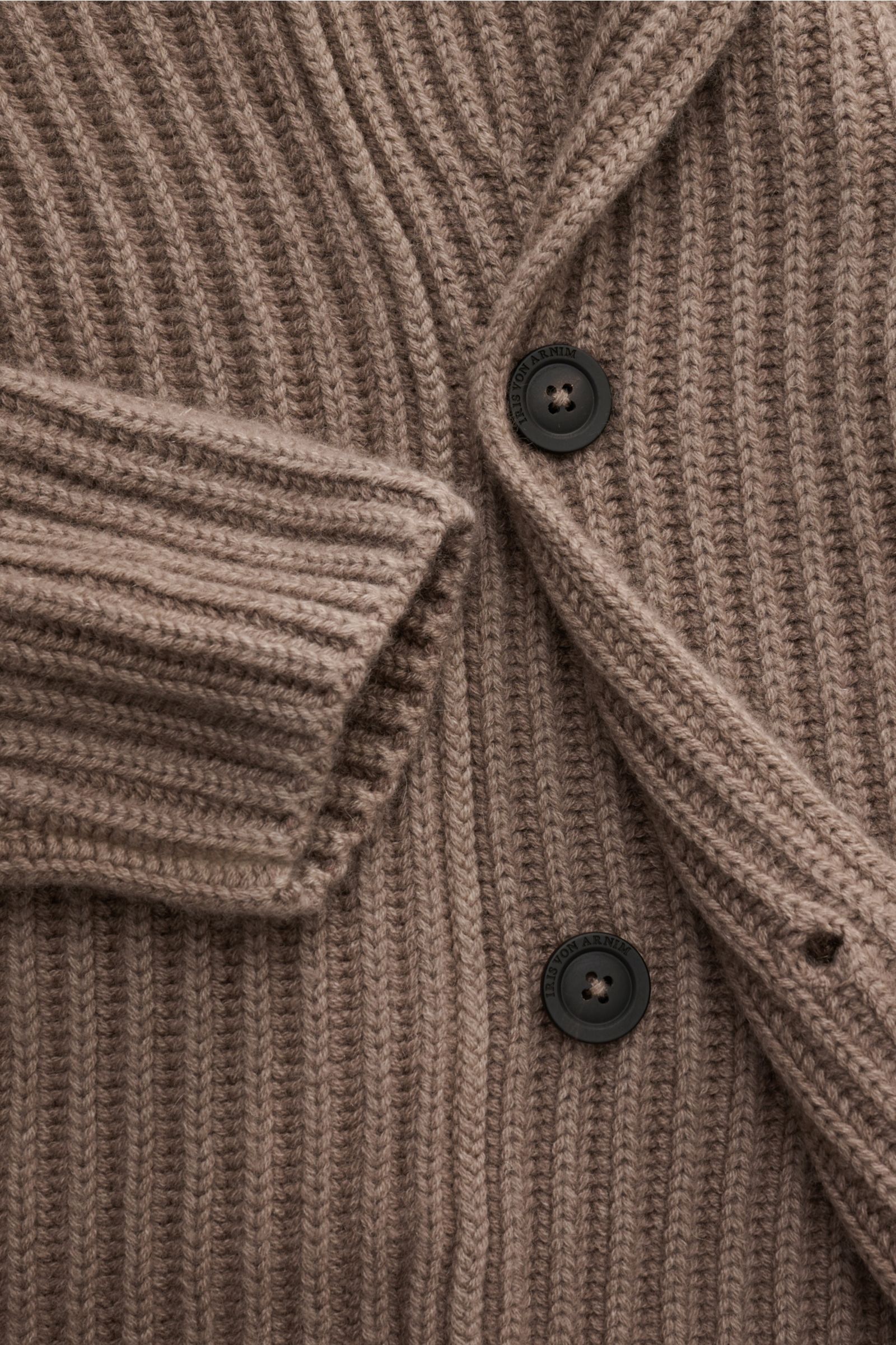 Close-up front view of Iris von Arnim Uomo Cashmere Rundhalspullover 'Arlington' taupe cardigan showing voluminous patent knit, soft ribbed cuffs, round neckline, slim fit, and black buttons with logo.

Kompromisslose Strickqualität – made to last: Der