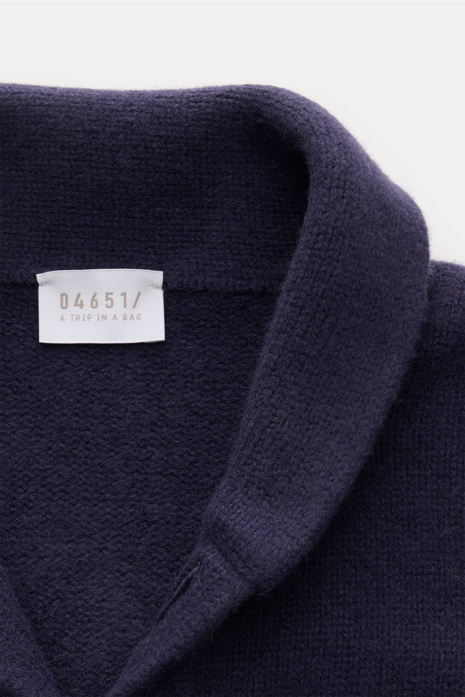 Nahaufnahme aus schräger Perspektive des navyfarbenen 04651/ A trip in a bag Cardigan 'Knit Overjacket' mit Schalkragen, weichem Wolle-Cashmere-Mix und mittelfeinem Strick.