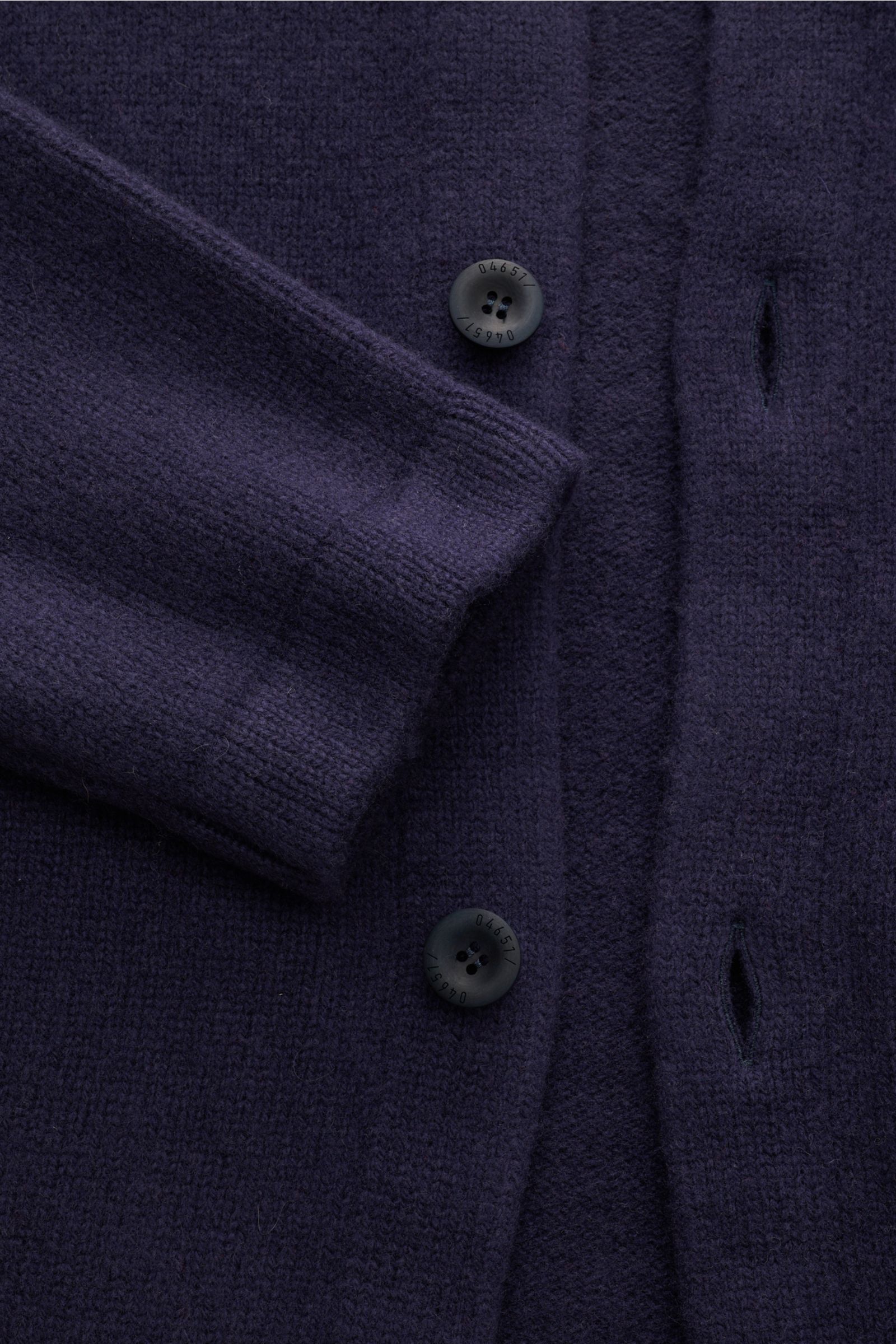 Nahaufnahme des 04651/ A trip in a bag Cardigan 'Knit Overjacket' navy aus mittelfeinem Strick mit Schalkragen, glatter Knopfleiste und Fronttaschen, fotografiert von oben. Quiet Luxury: Mix aus Wolle und Cashmere, weicher Griff, Regular Fit.