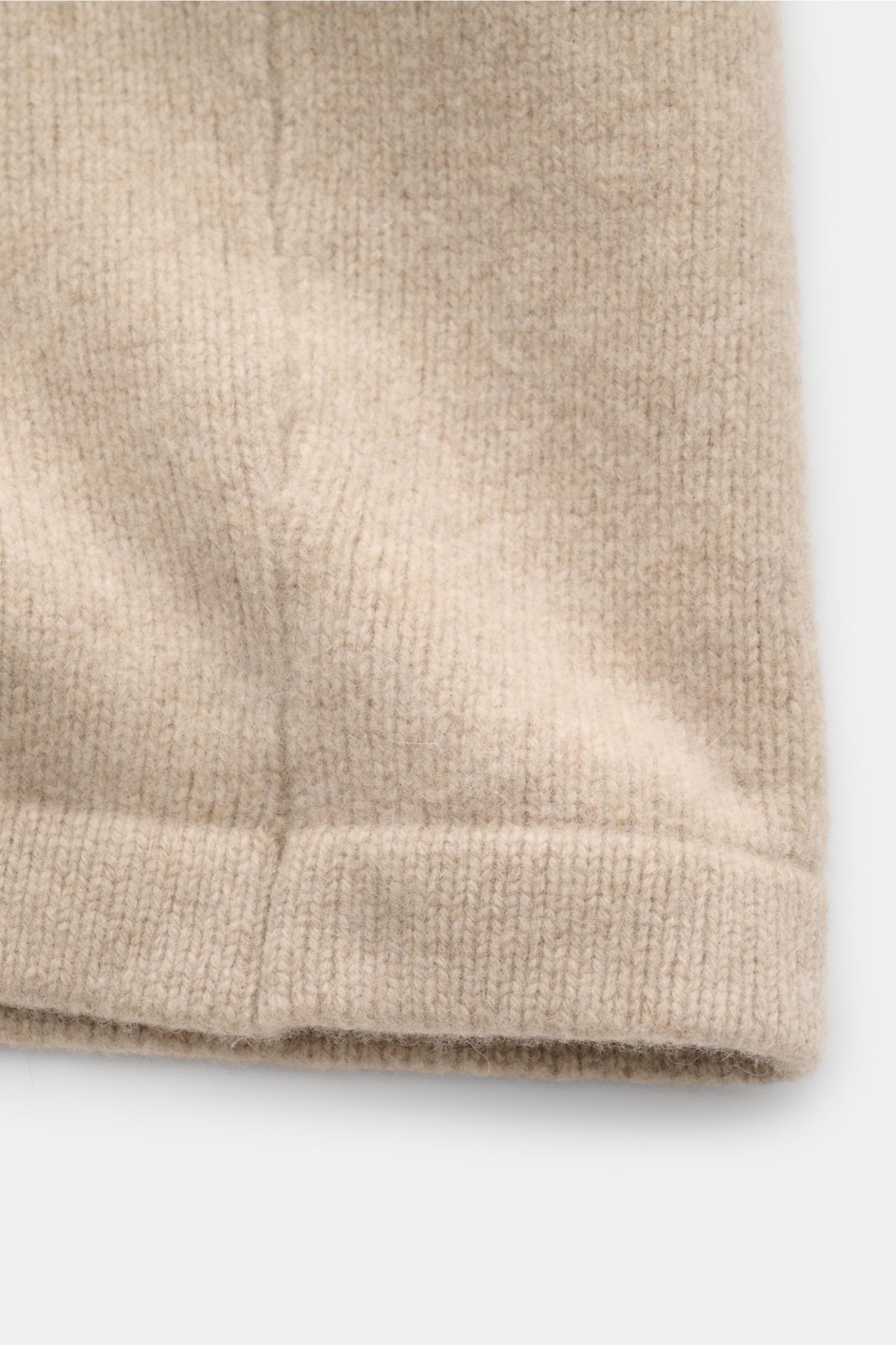 Detailansicht des 04651/ A trip in a bag Cardigan 'Knit Overjacket' beige meliert aus mittelfeinem, weichem Woll-Cashmere-Strick mit Bündchen, fotografiert von vorne unten.