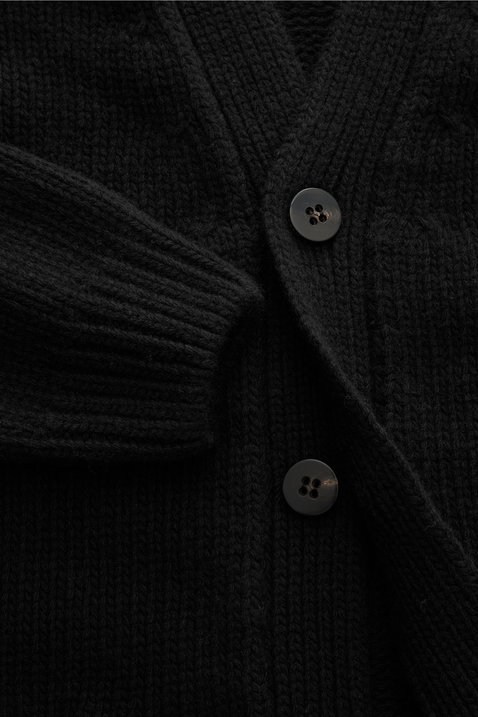 04651/ A trip in a bag Cardigan 'Bold' schwarz in Nahaufnahme von vorne, grober Strick, reine Lammwolle, weicher Griff, Oversized Fit, Vier-Knopf-Leiste, aufgesetzte Fronttaschen.